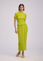 A model wears the ISSEY MIYAKE WAVELET ENSEMBLE skirt.