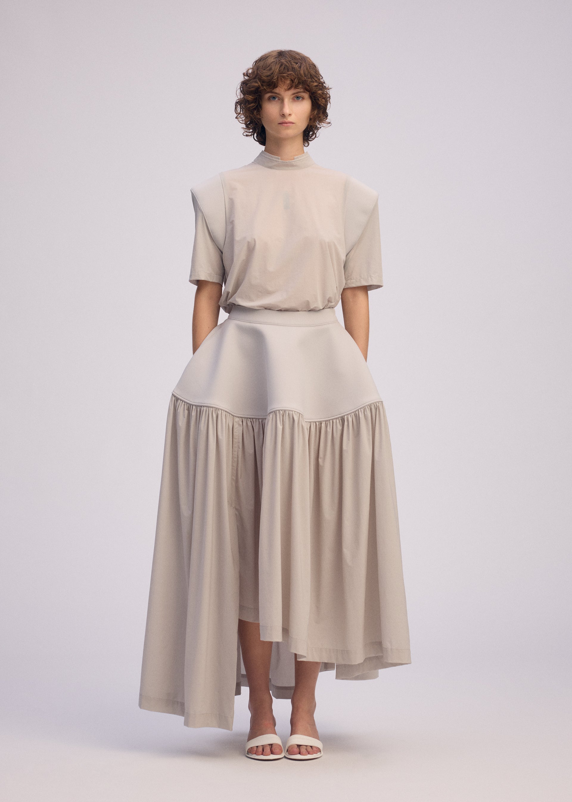 A model wears the ISSEY MIYAKE MUTE mute-skirt-light-grey.