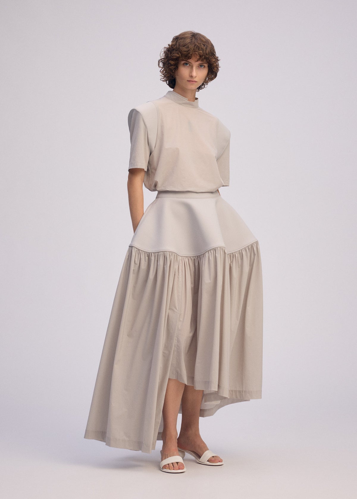 A model wears the ISSEY MIYAKE MUTE mute-skirt-light-grey.