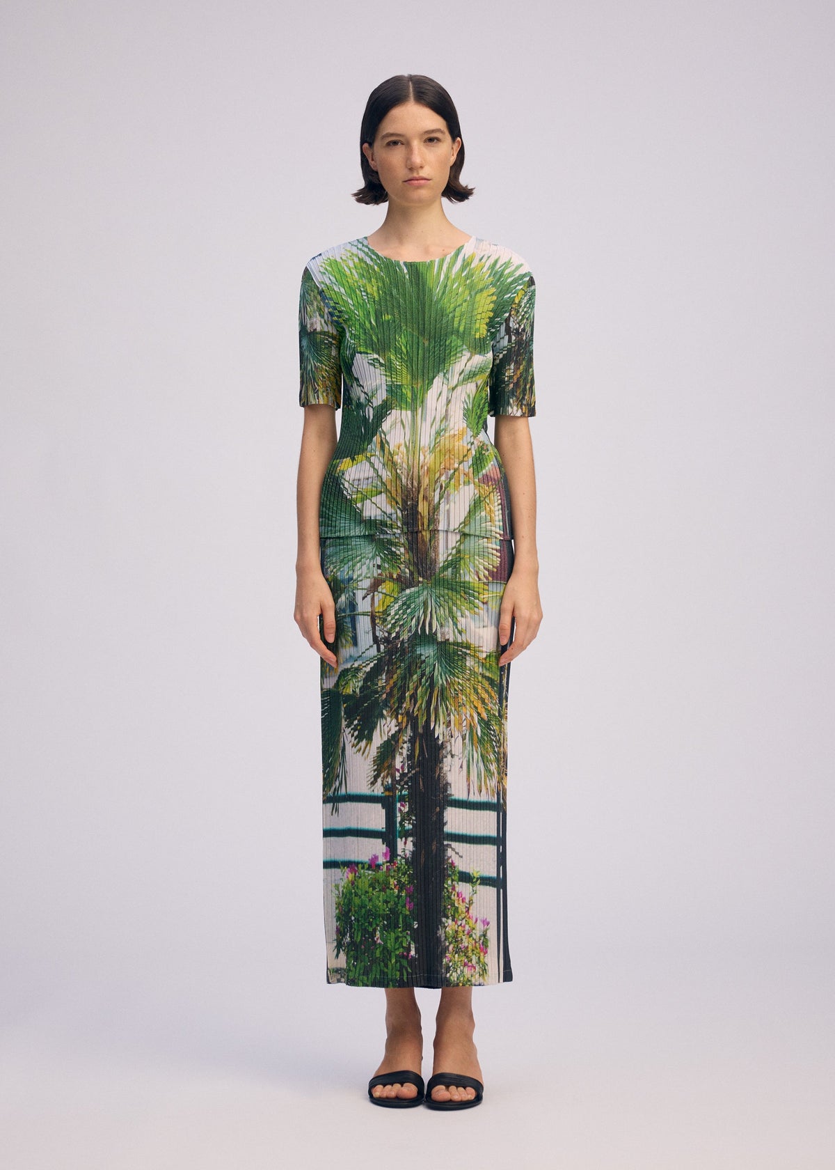 A model wears the ISSEY MIYAKE URBAN JUNGLE PLEATS skirt.