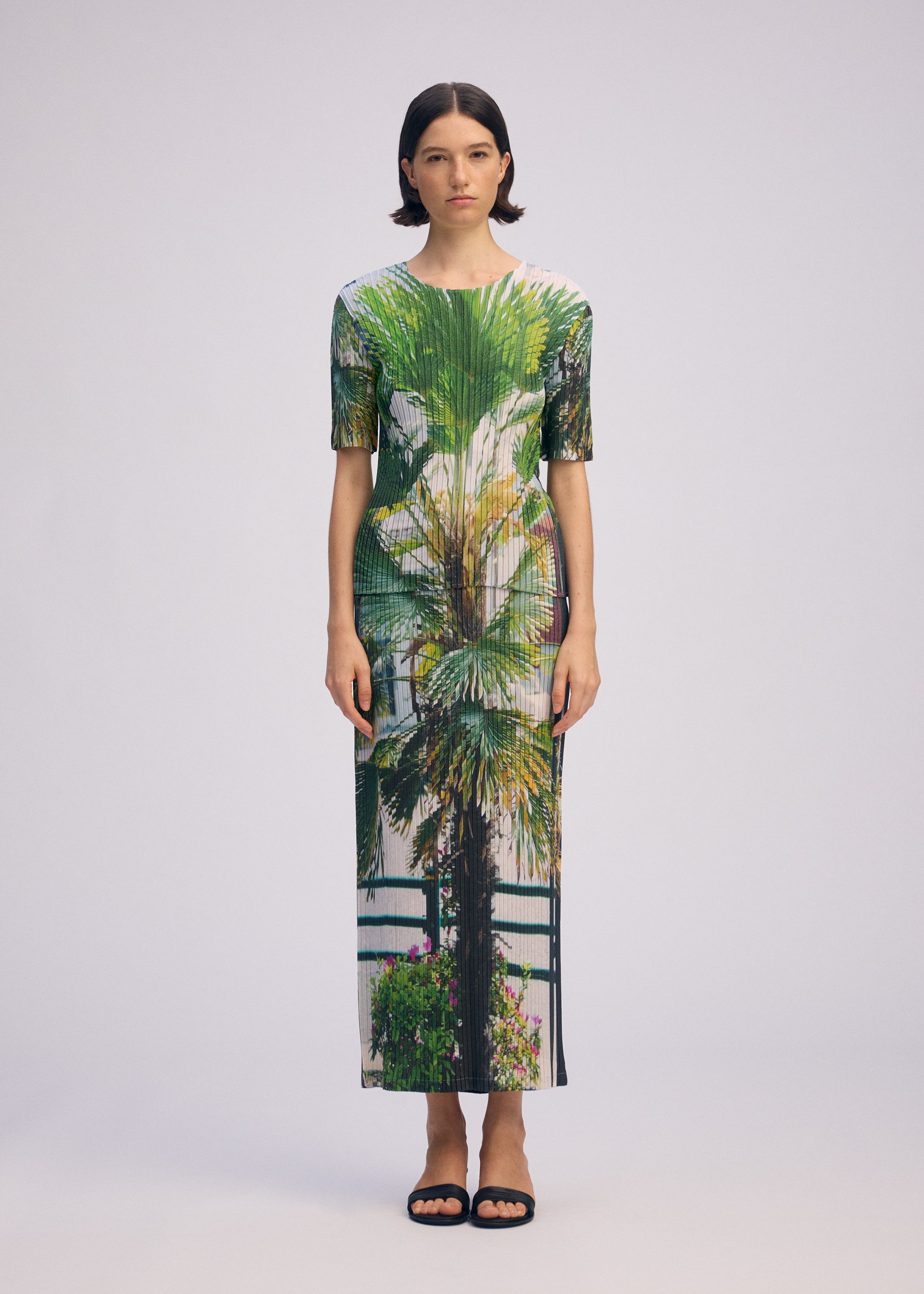 A model wears the ISSEY MIYAKE URBAN JUNGLE PLEATS skirt.