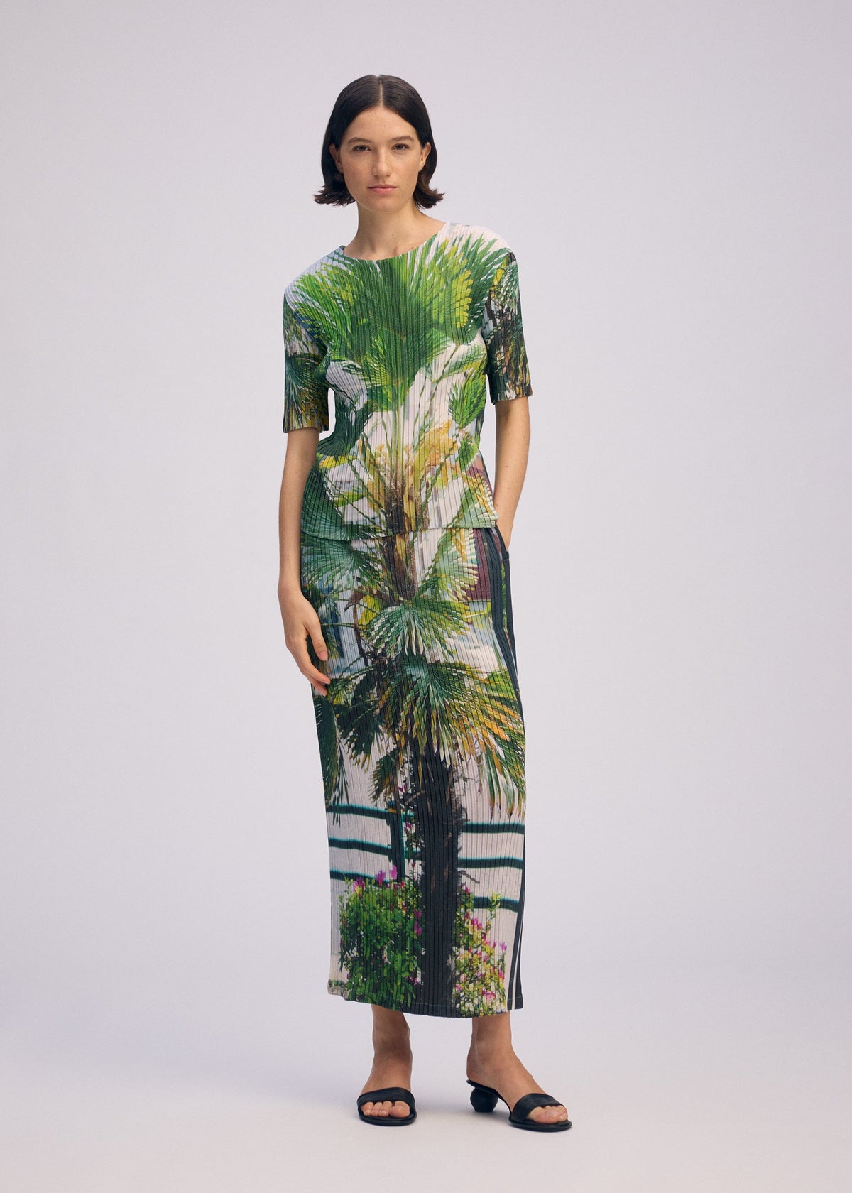 A model wears the ISSEY MIYAKE URBAN JUNGLE PLEATS skirt.