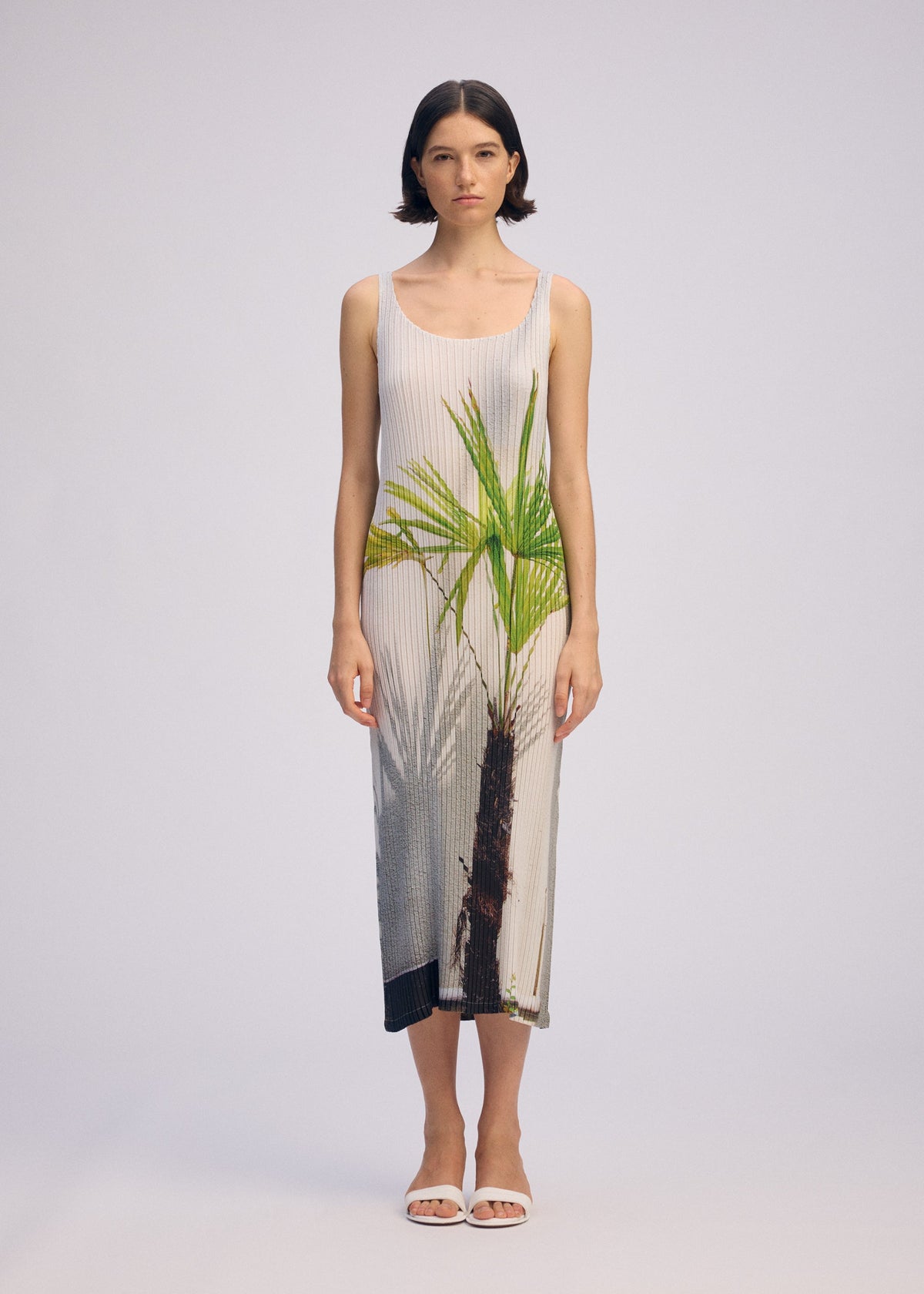 A model wears the ISSEY MIYAKE URBAN JUNGLE PLEATS dress.