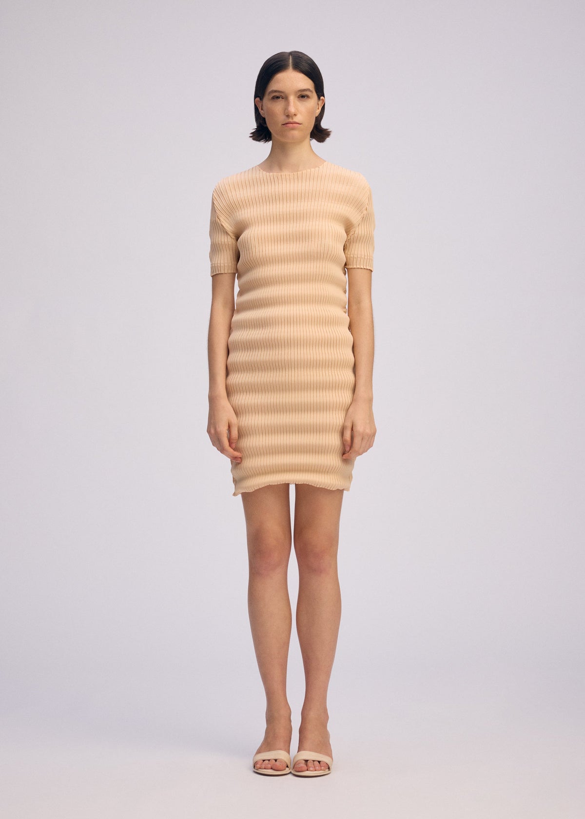 A model wears the ISSEY MIYAKE SPRING PLEATS spring-pleats-dress-black.