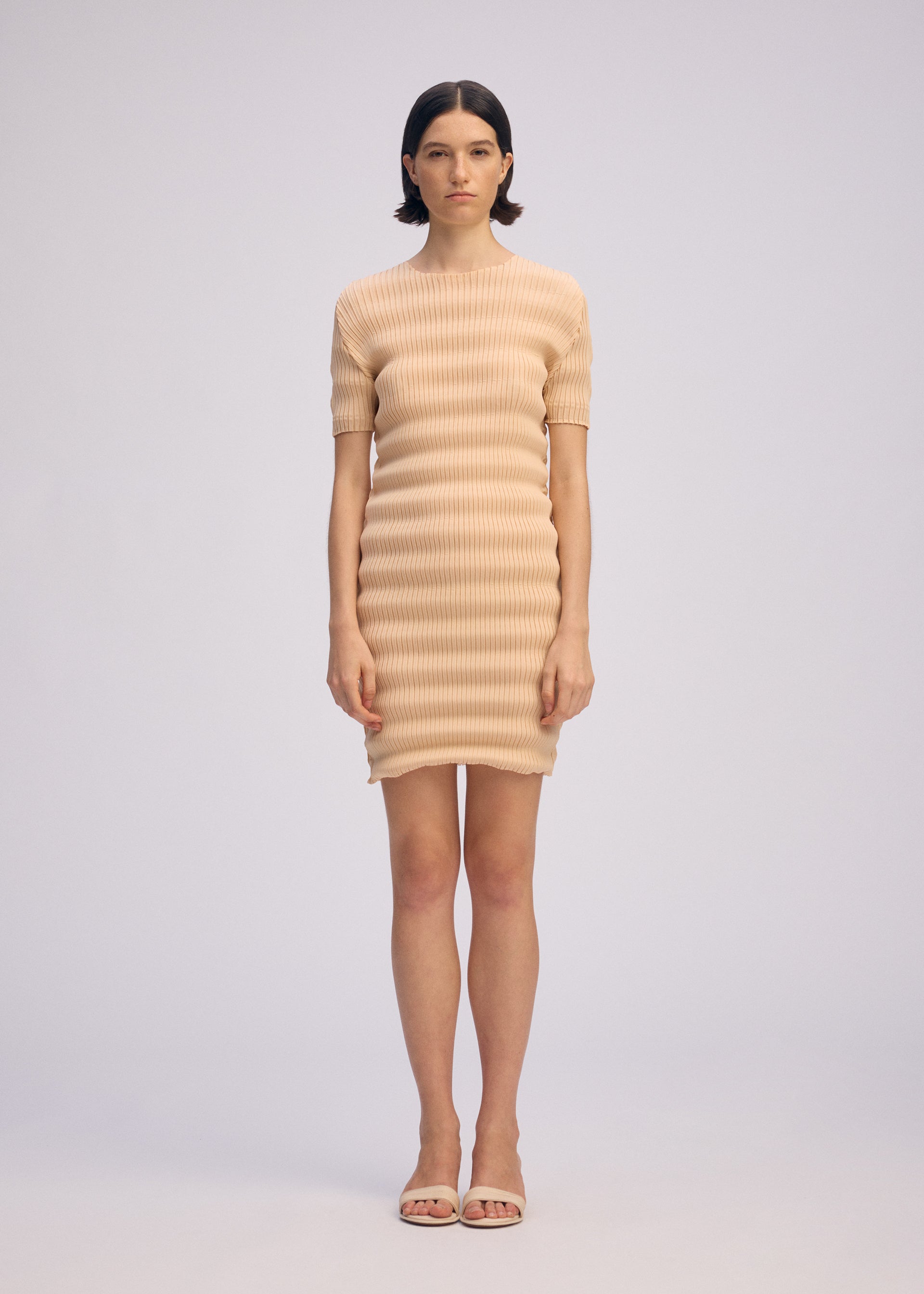 A model wears the ISSEY MIYAKE SPRING PLEATS spring-pleats-dress-black.