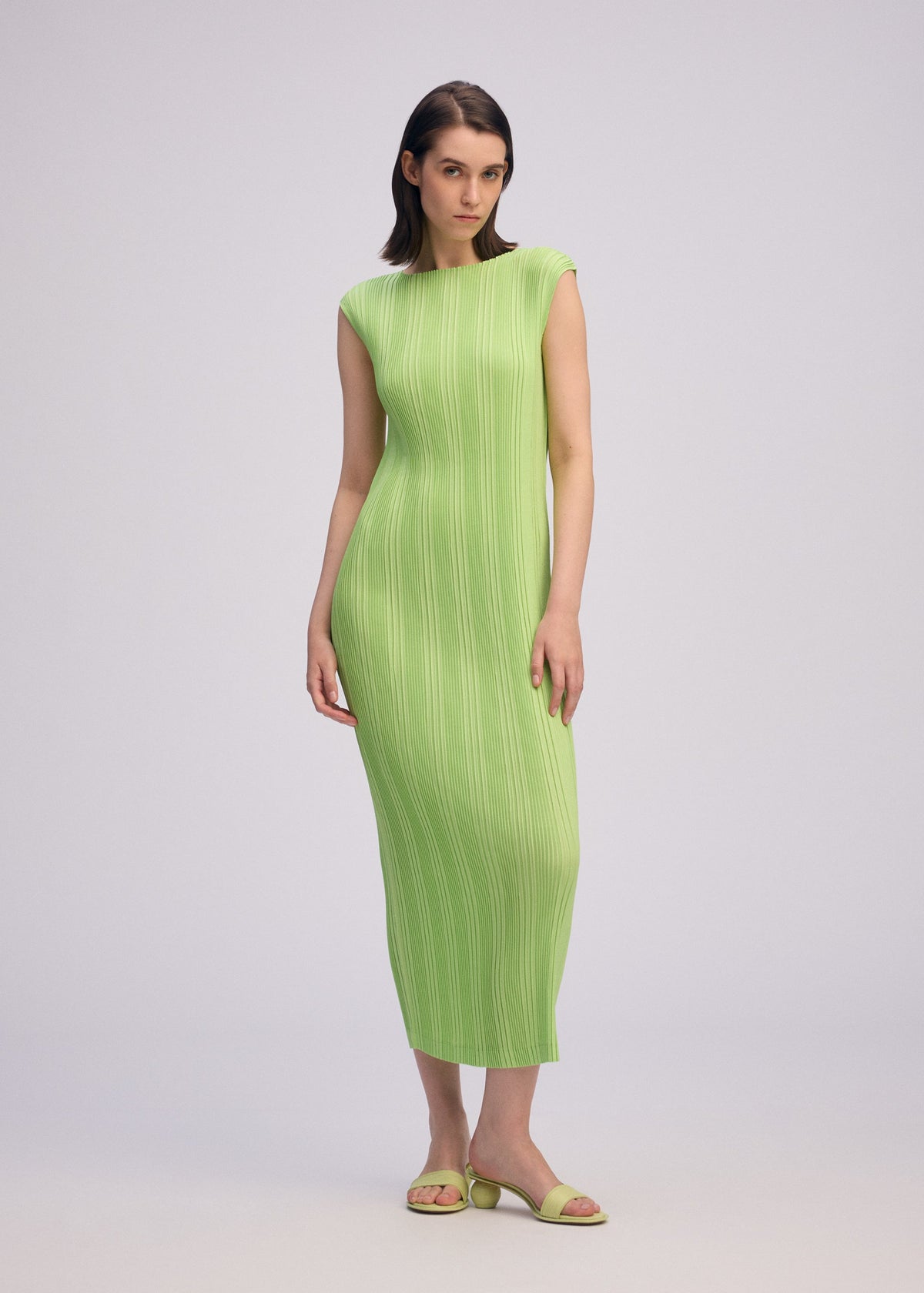 A model wears the ISSEY MIYAKE LINEN LIKE RIB PLEATS dress.