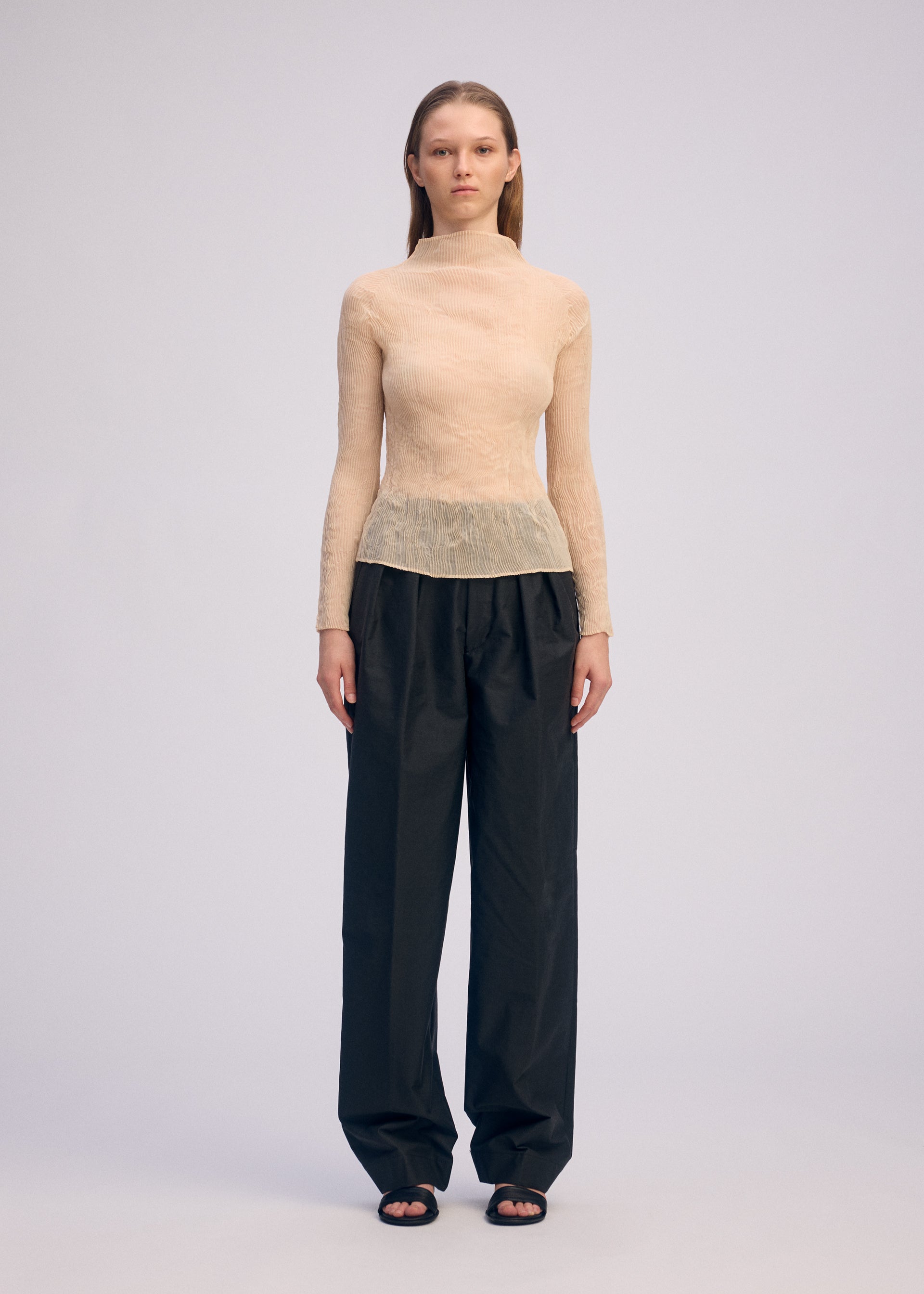 A model wears the ISSEY MIYAKE CHIFFON TWIST 1 clothing.