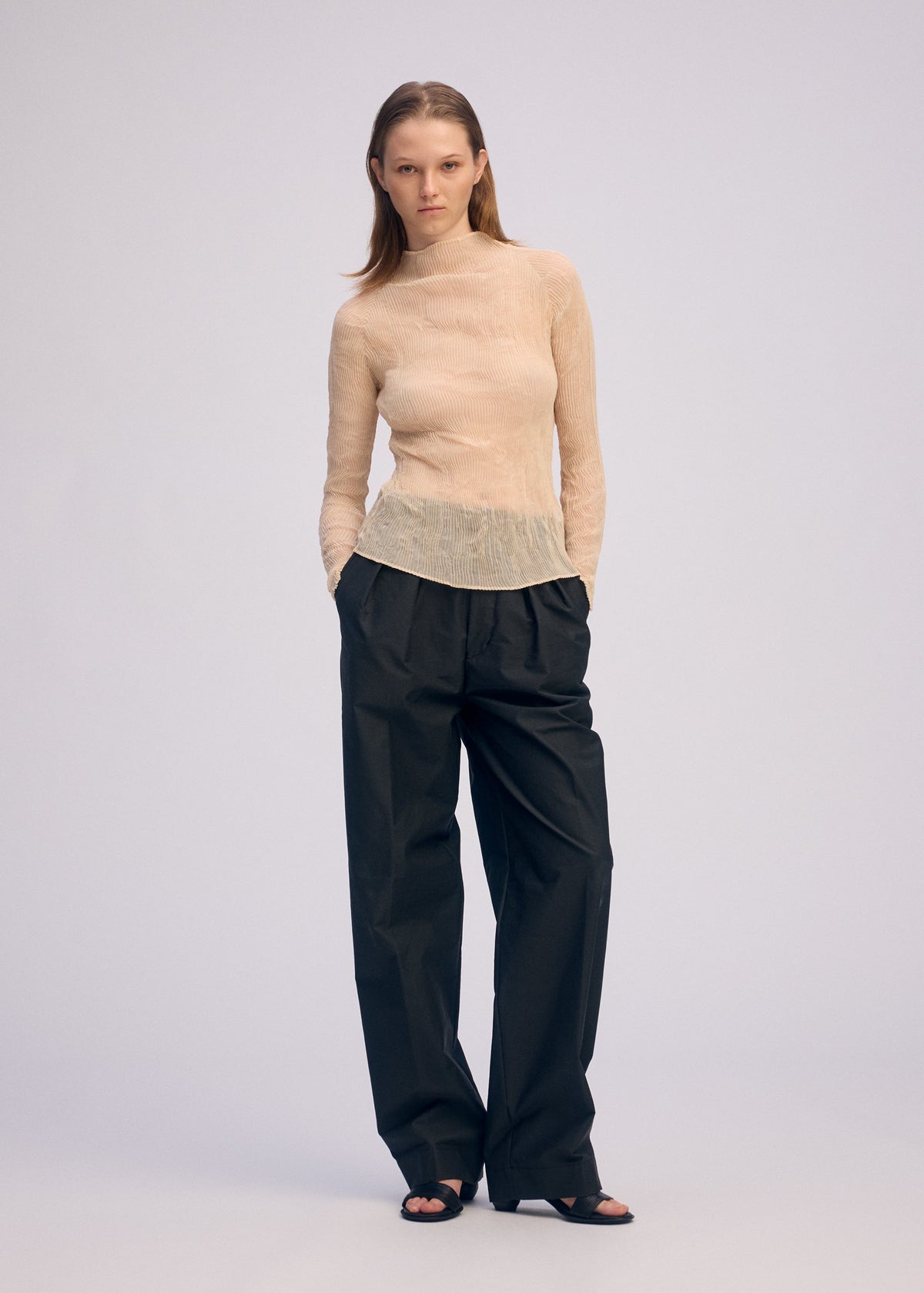 A model wears the ISSEY MIYAKE CHIFFON TWIST 1 clothing.