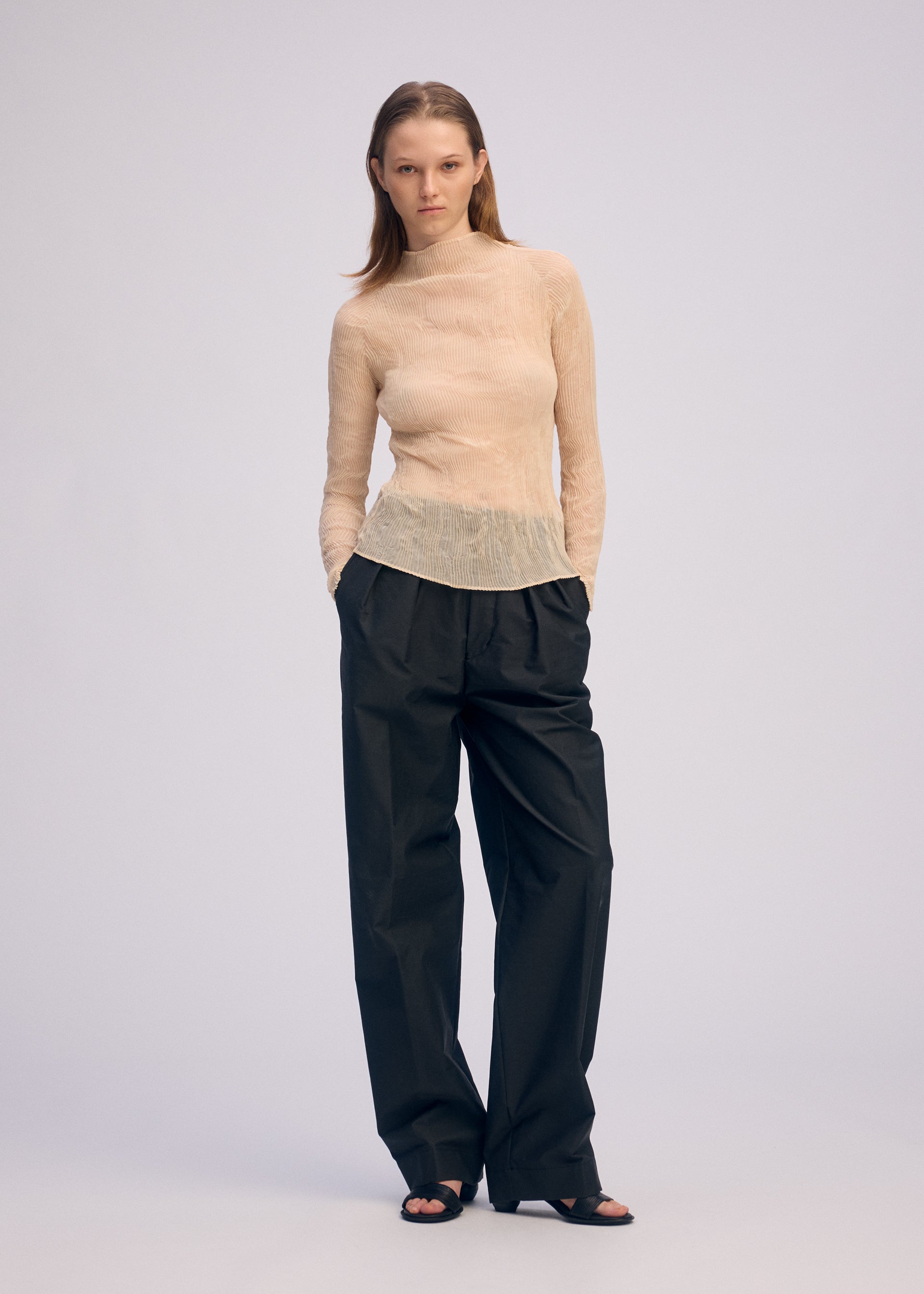 A model wears the ISSEY MIYAKE CHIFFON TWIST 1 clothing.
