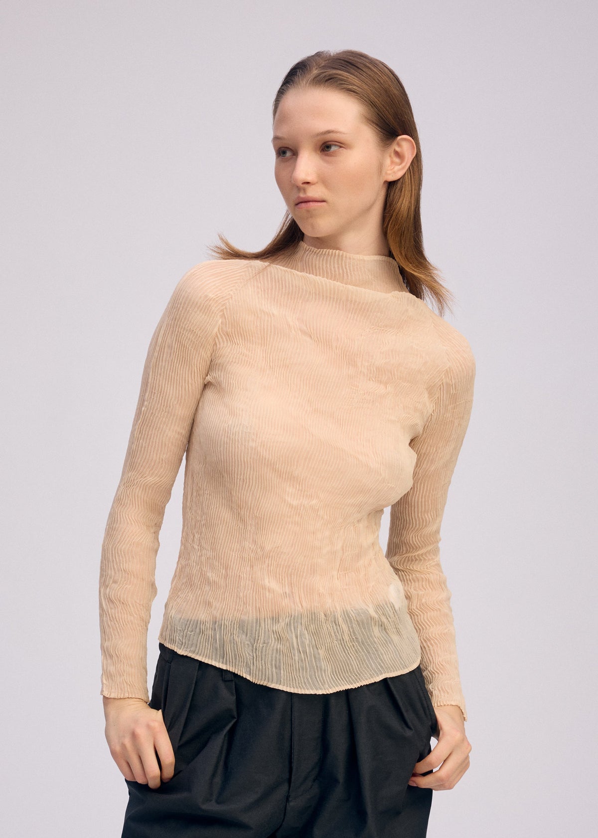 A model wears the ISSEY MIYAKE CHIFFON TWIST 1 clothing.