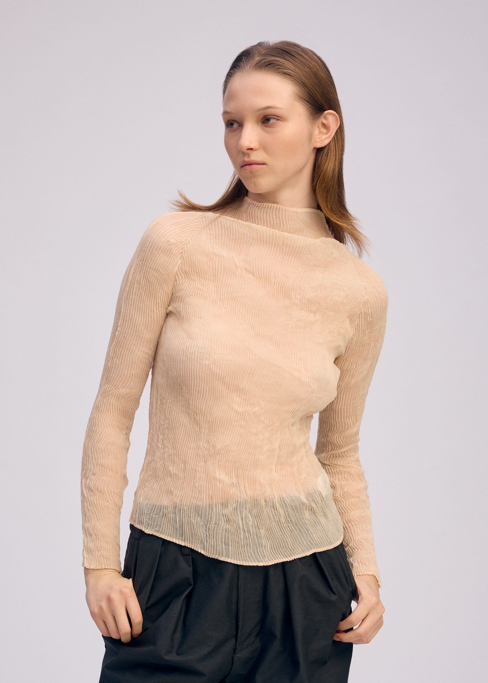 A model wears the ISSEY MIYAKE CHIFFON TWIST 1 clothing.