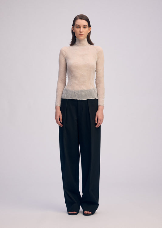 A model wears the ISSEY MIYAKE CHIFFON TWIST 3 top.