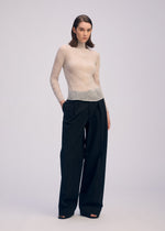 A model wears the ISSEY MIYAKE CHIFFON TWIST 3 top.