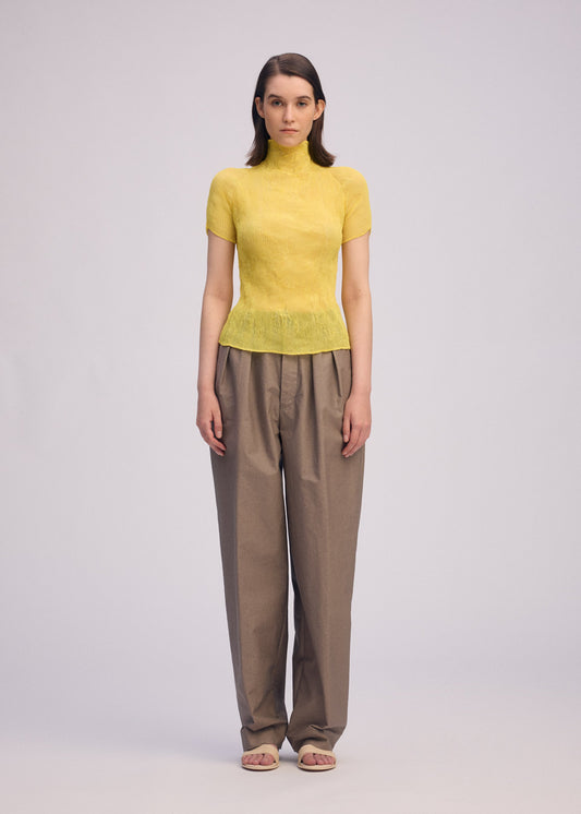 A model wears the ISSEY MIYAKE CHIFFON TWIST 3 top.