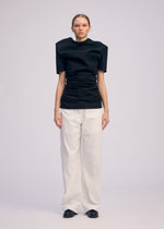 A model wears the ISSEY MIYAKE GENERIC WEAR shirt.