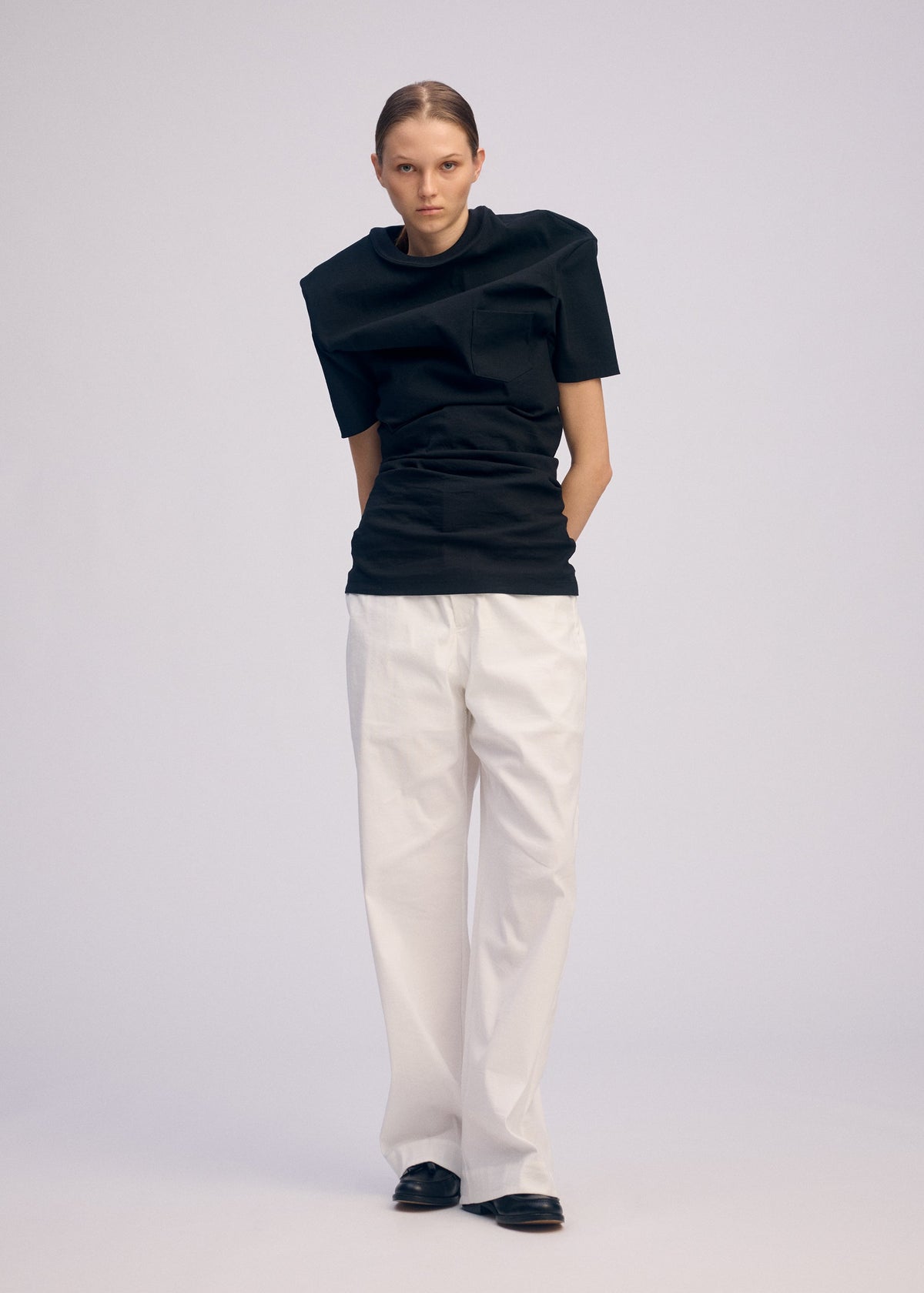 A model wears the ISSEY MIYAKE GENERIC WEAR shirt.
