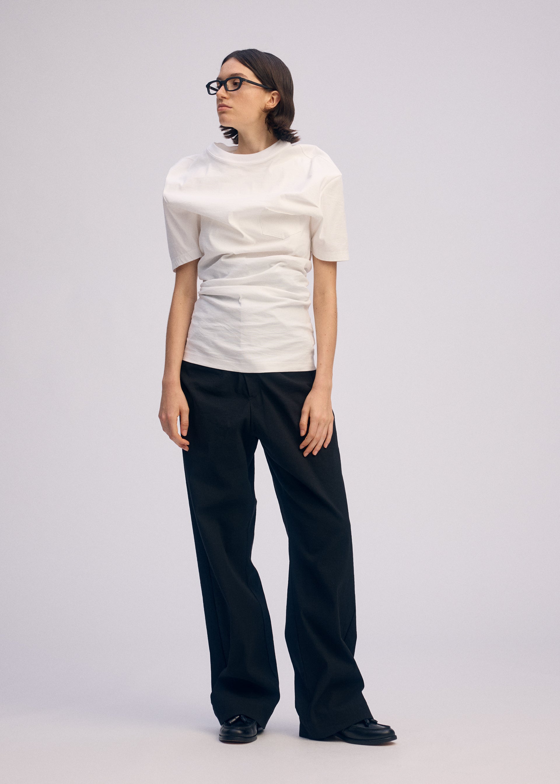 A model wears the ISSEY MIYAKE GENERIC WEAR shirt.