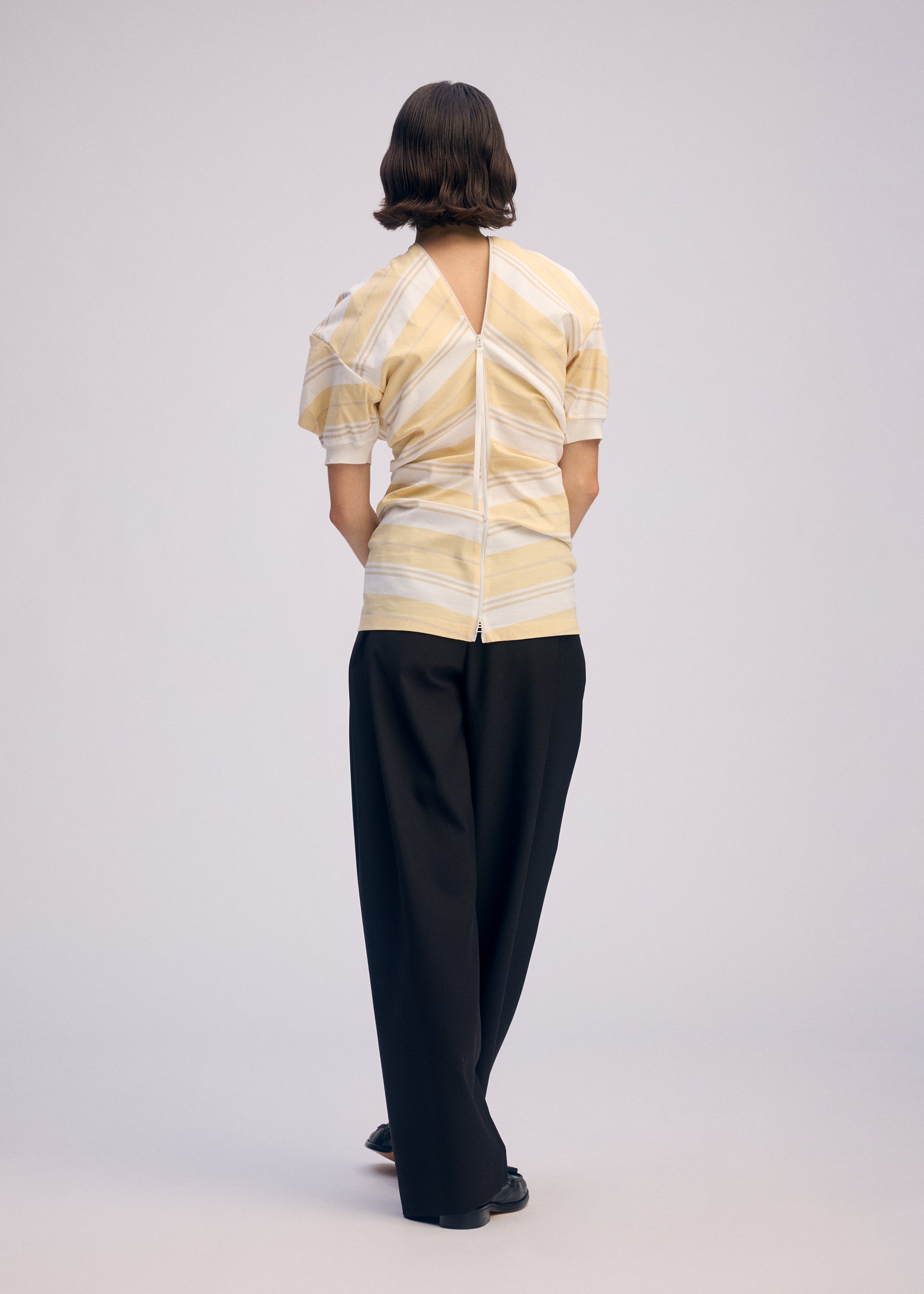 A model wears the ISSEY MIYAKE GENERIC WEAR STRIPES shirt.