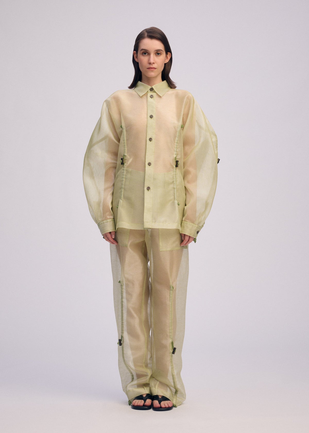 A model wears the ISSEY MIYAKE DRAW TO FORM shirt.