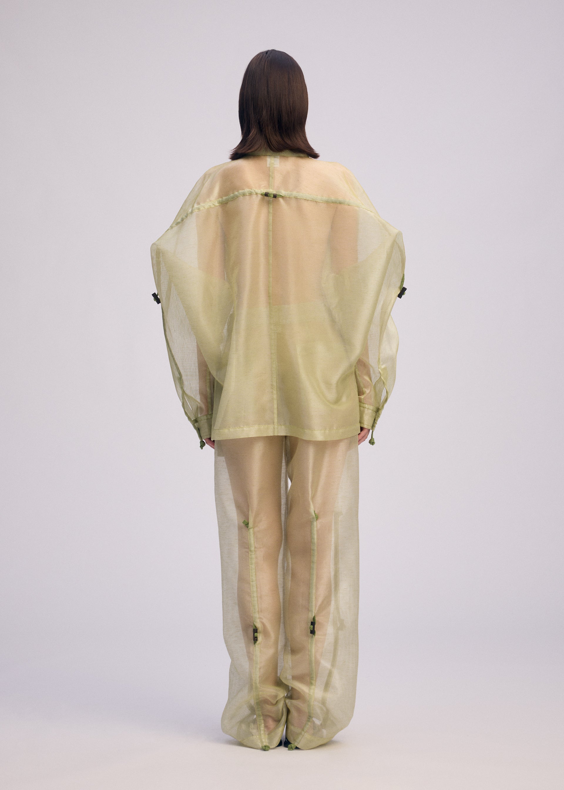 A model wears the ISSEY MIYAKE DRAW TO FORM shirt.