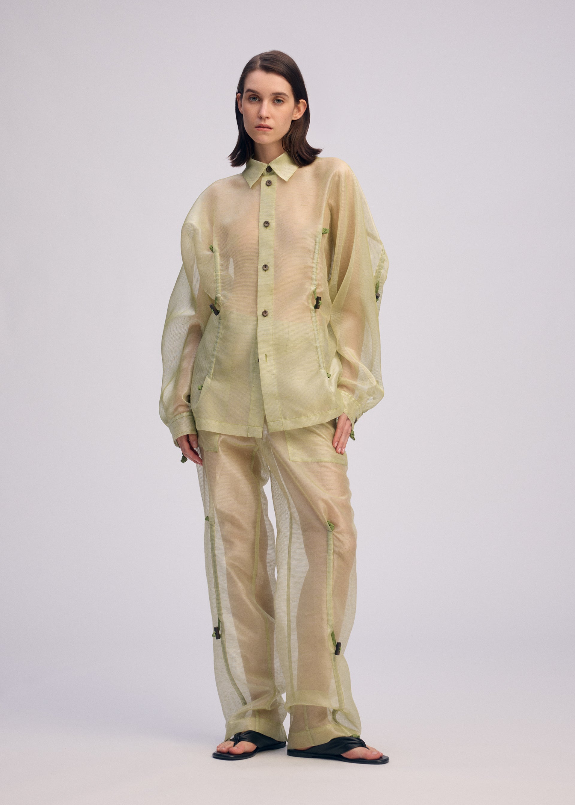 A model wears the ISSEY MIYAKE DRAW TO FORM shirt.
