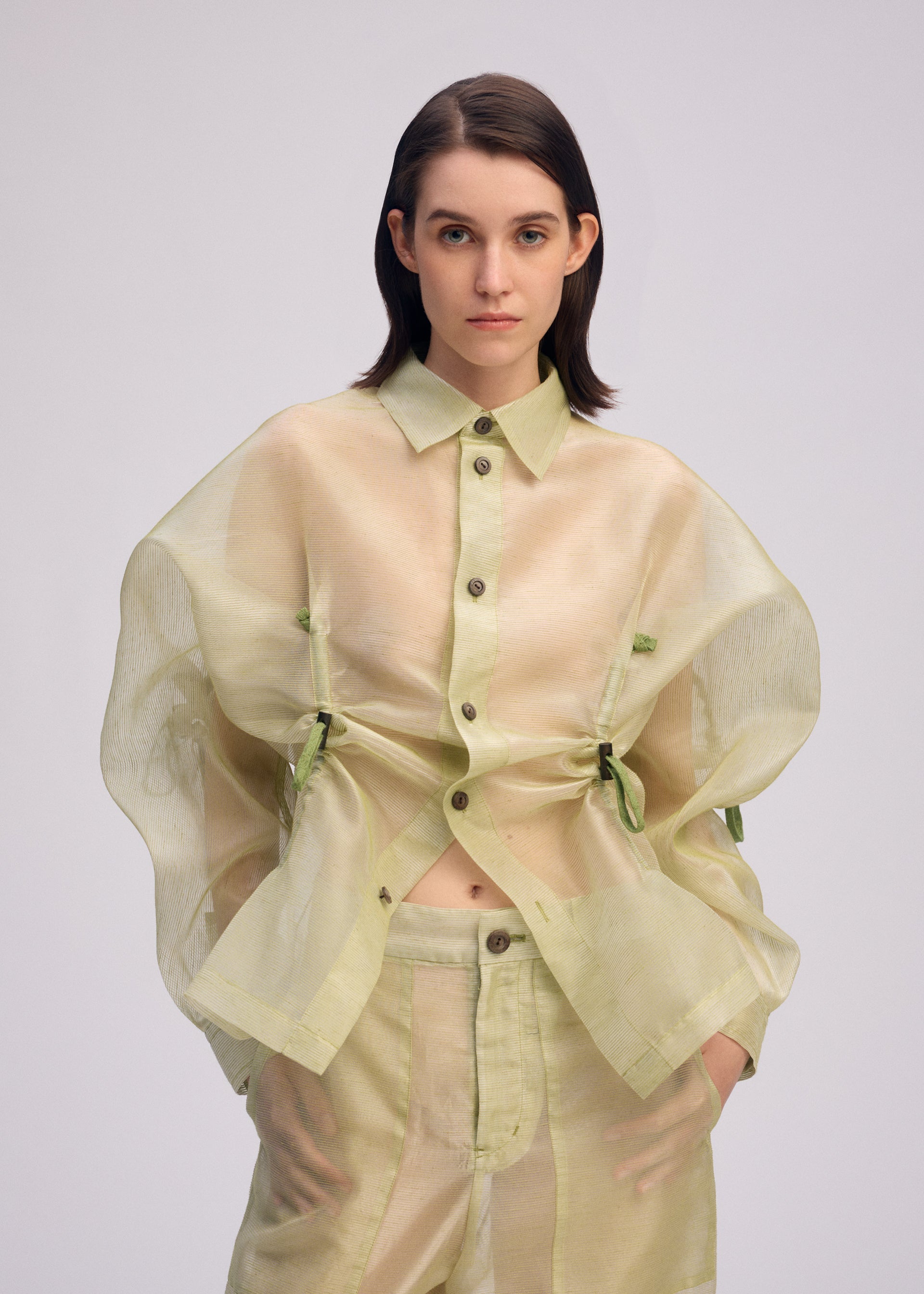 A model wears the ISSEY MIYAKE DRAW TO FORM shirt.