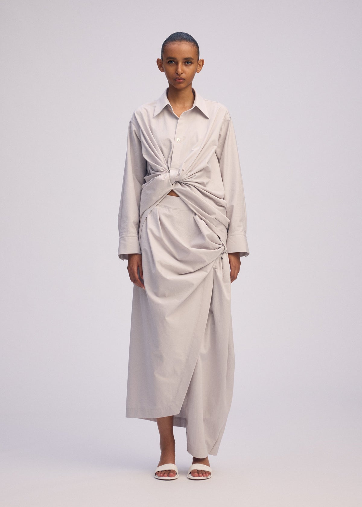 A model wears the ISSEY MIYAKE TWISTED DRAPE shirt.