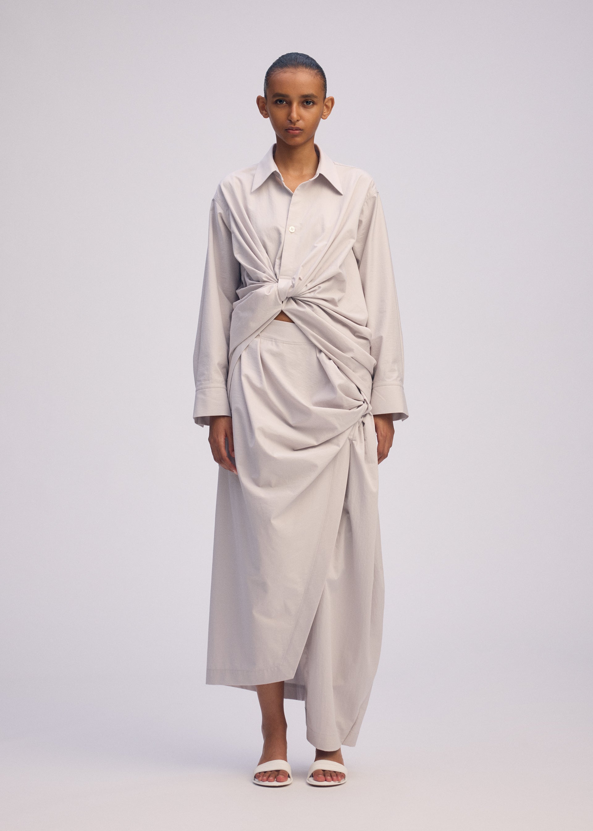 A model wears the ISSEY MIYAKE TWISTED DRAPE shirt.