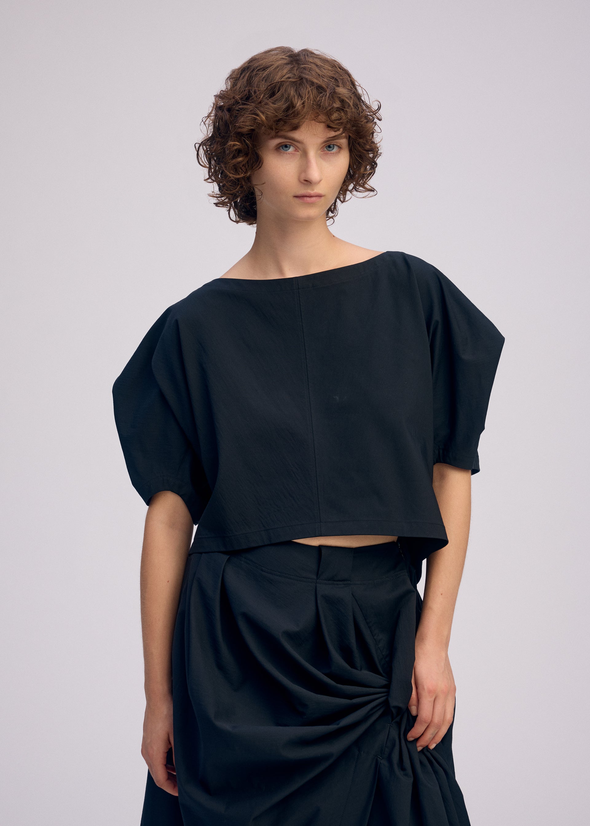 A model wears the ISSEY MIYAKE TWISTED DRAPE top.