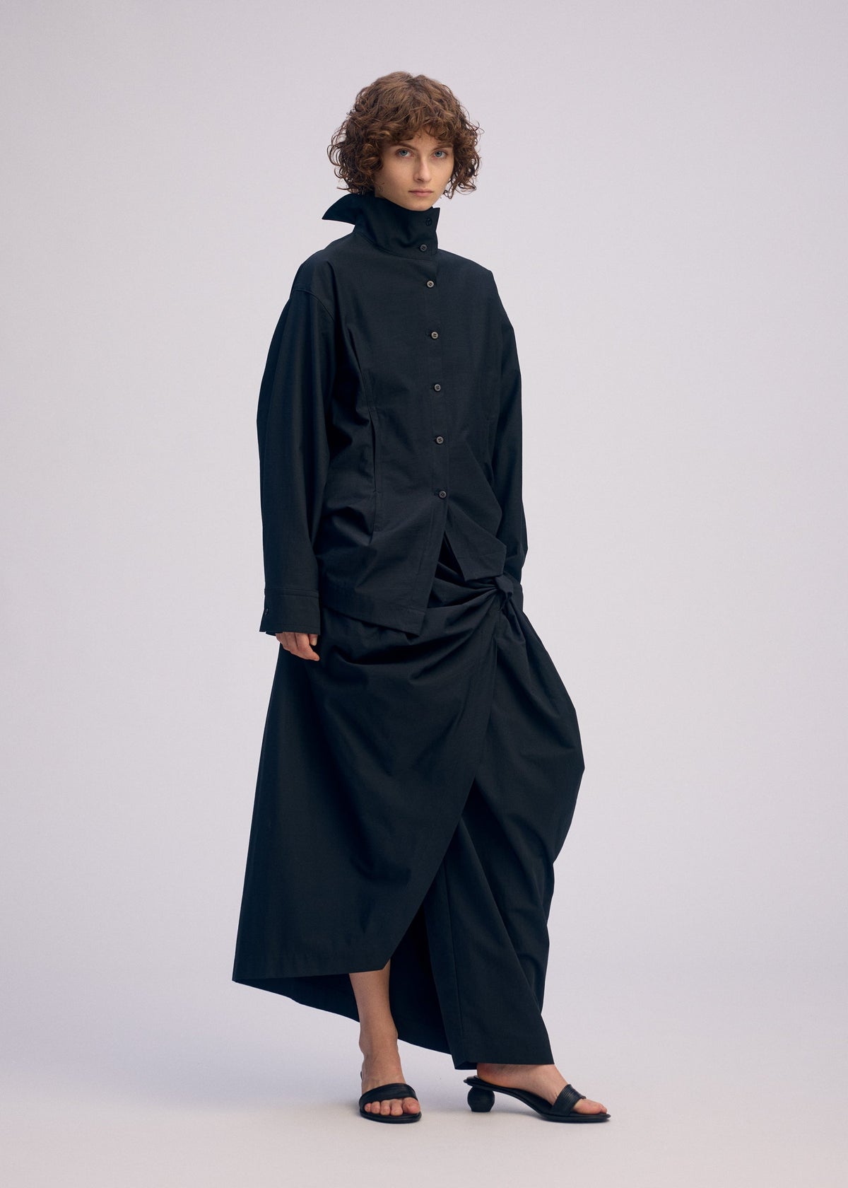 A model wears the ISSEY MIYAKE TWISTED DRAPE shirt.