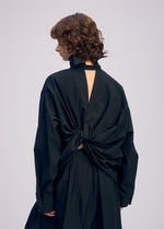 A model wears the ISSEY MIYAKE TWISTED DRAPE shirt.