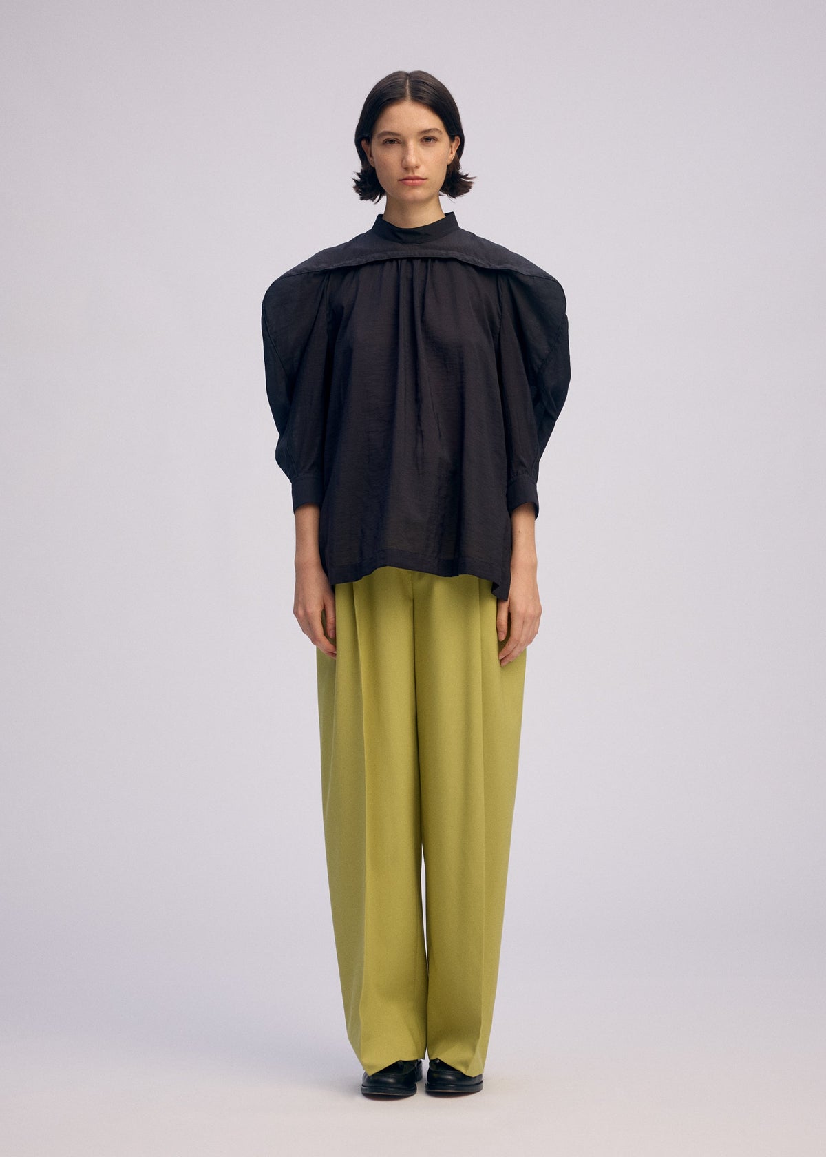 A model wears the ISSEY MIYAKE R SHIRT SHEER shirt.