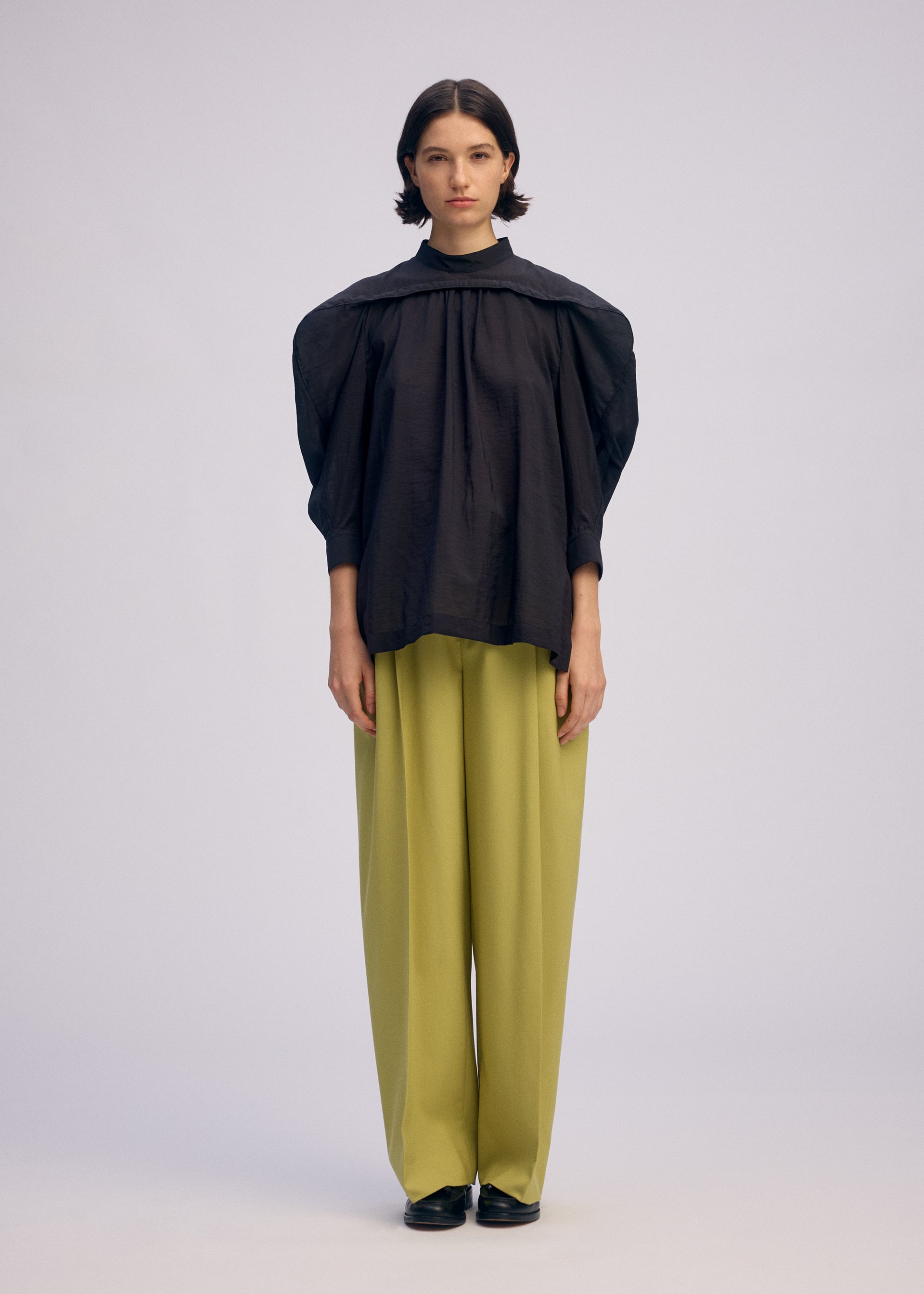 A model wears the ISSEY MIYAKE R SHIRT SHEER shirt.