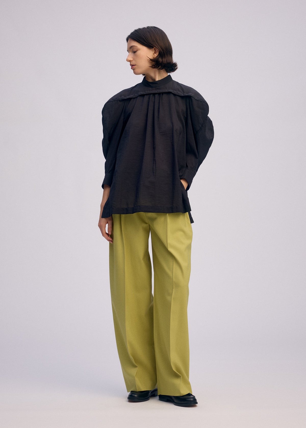 A model wears the ISSEY MIYAKE R SHIRT SHEER shirt.