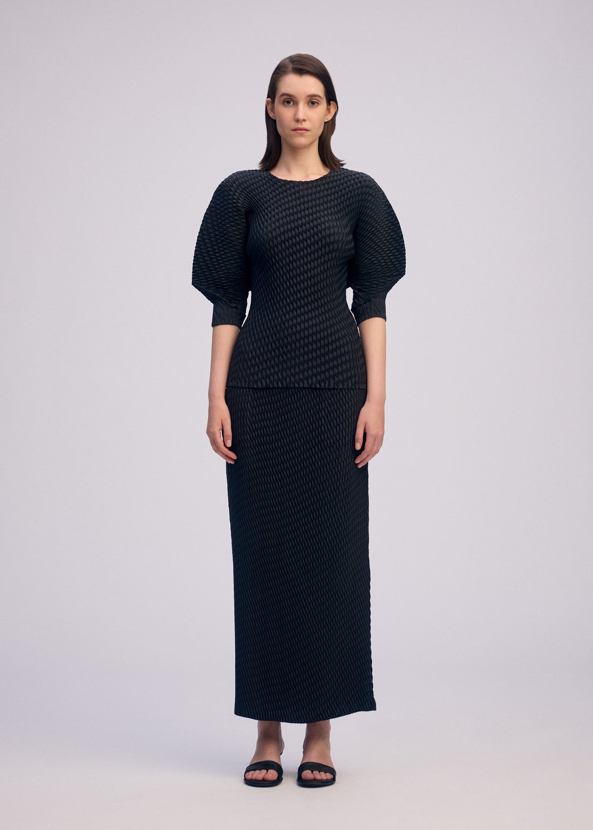 A model wears the ISSEY MIYAKE SLEEK PLEATS sleek-pleats-shirt-light-grey-1.