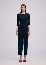 A model wears the ISSEY MIYAKE RHOMBUS PLEATS shirt.