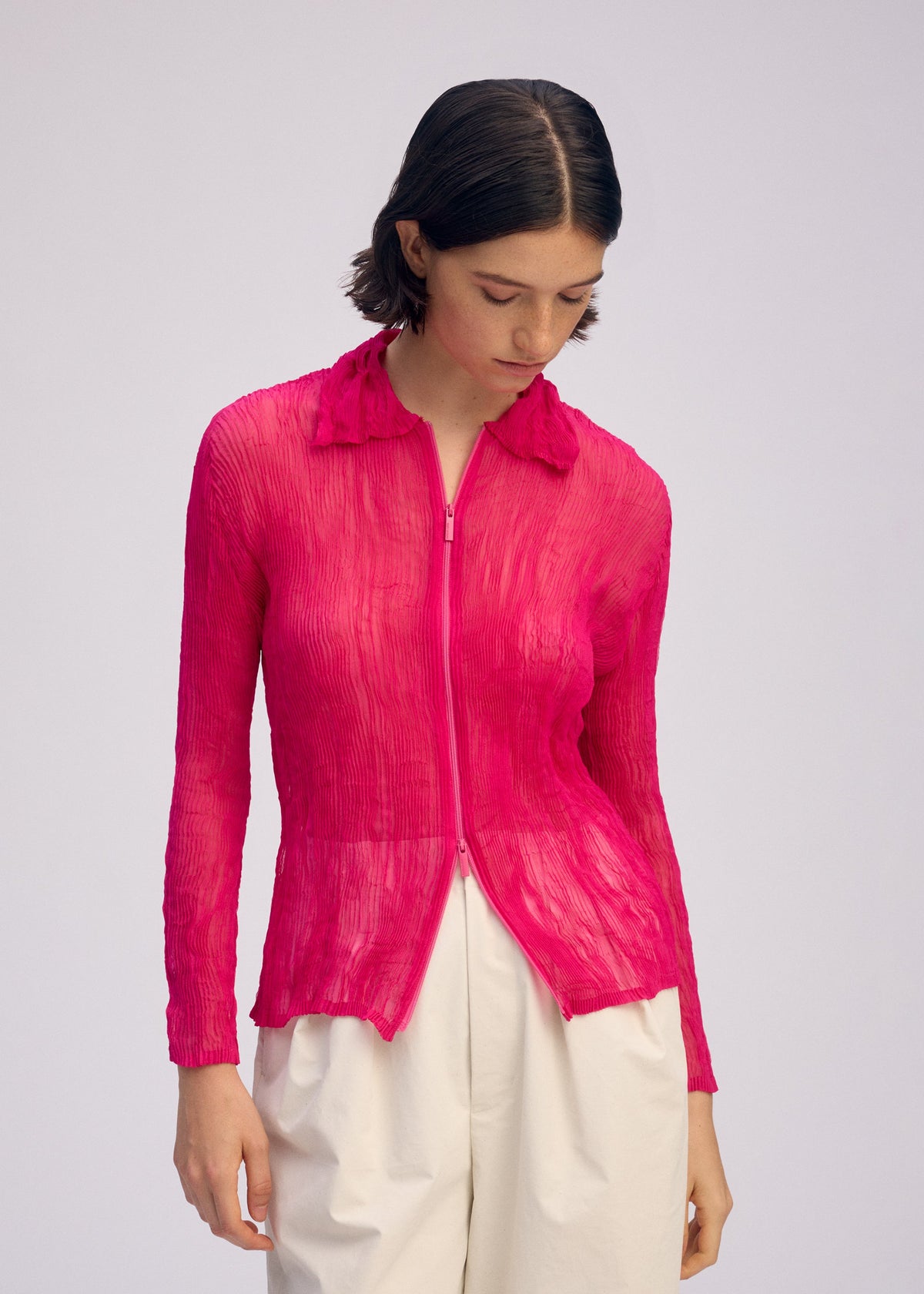 A model wears the ISSEY MIYAKE CHIFFON TWIST 1 clothing.