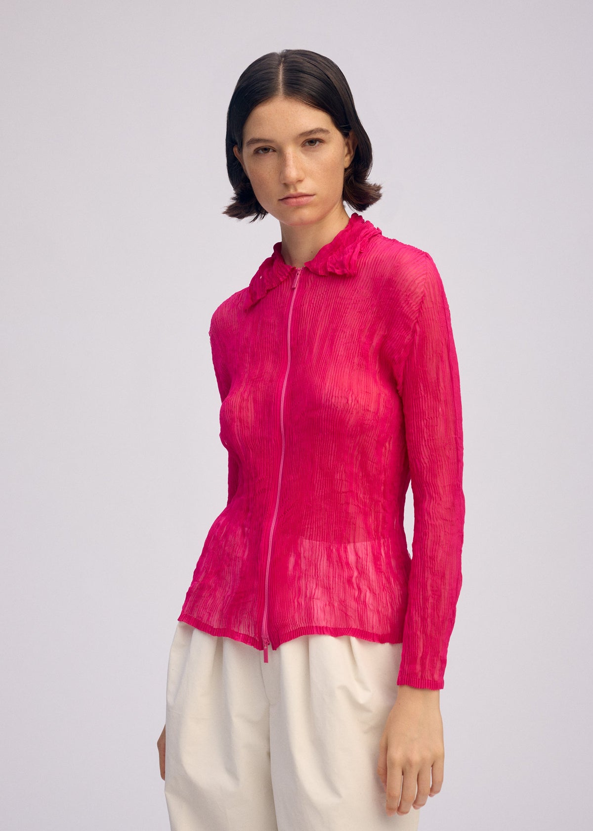 A model wears the ISSEY MIYAKE CHIFFON TWIST 1 clothing.