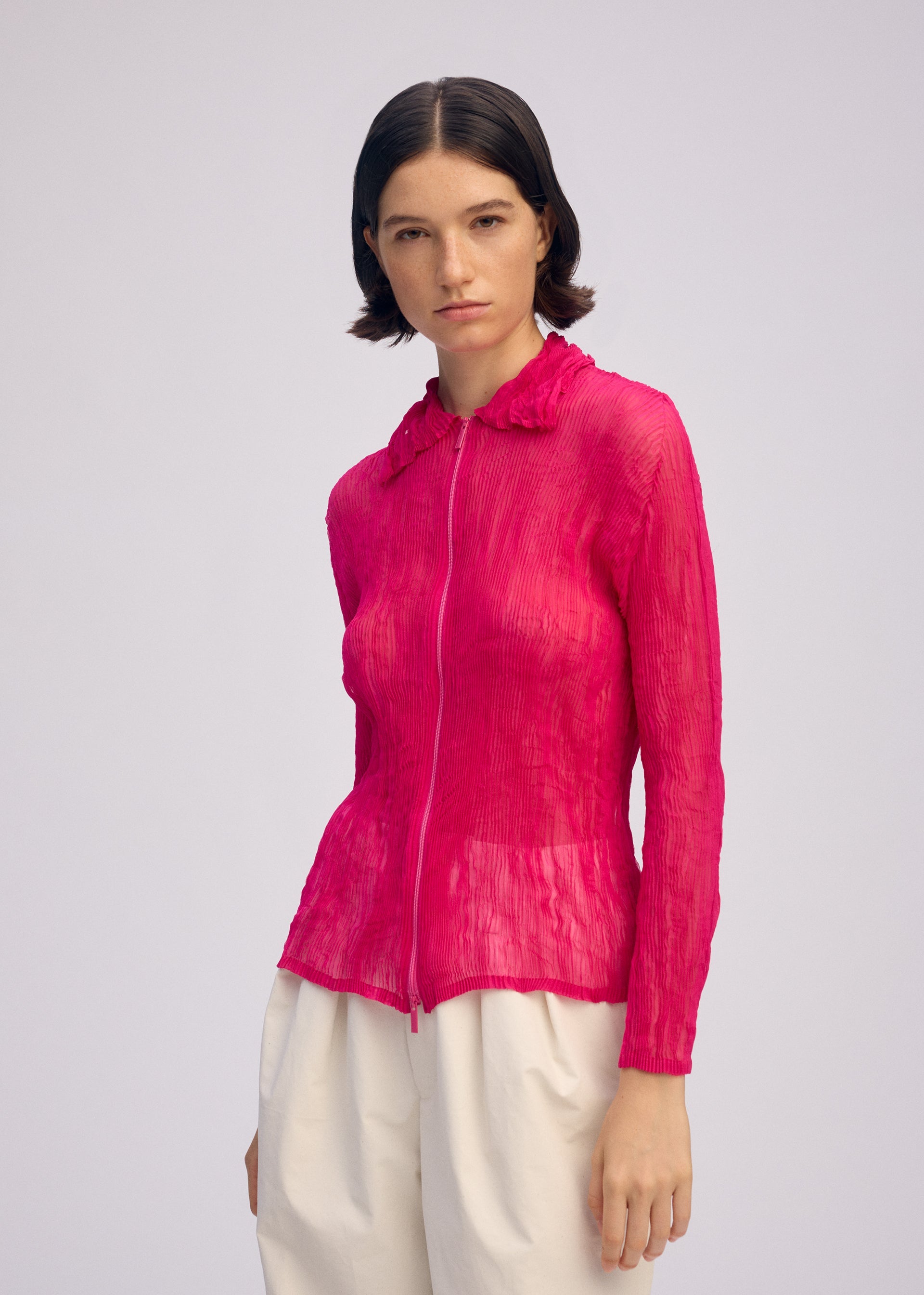 A model wears the ISSEY MIYAKE CHIFFON TWIST 1 clothing.