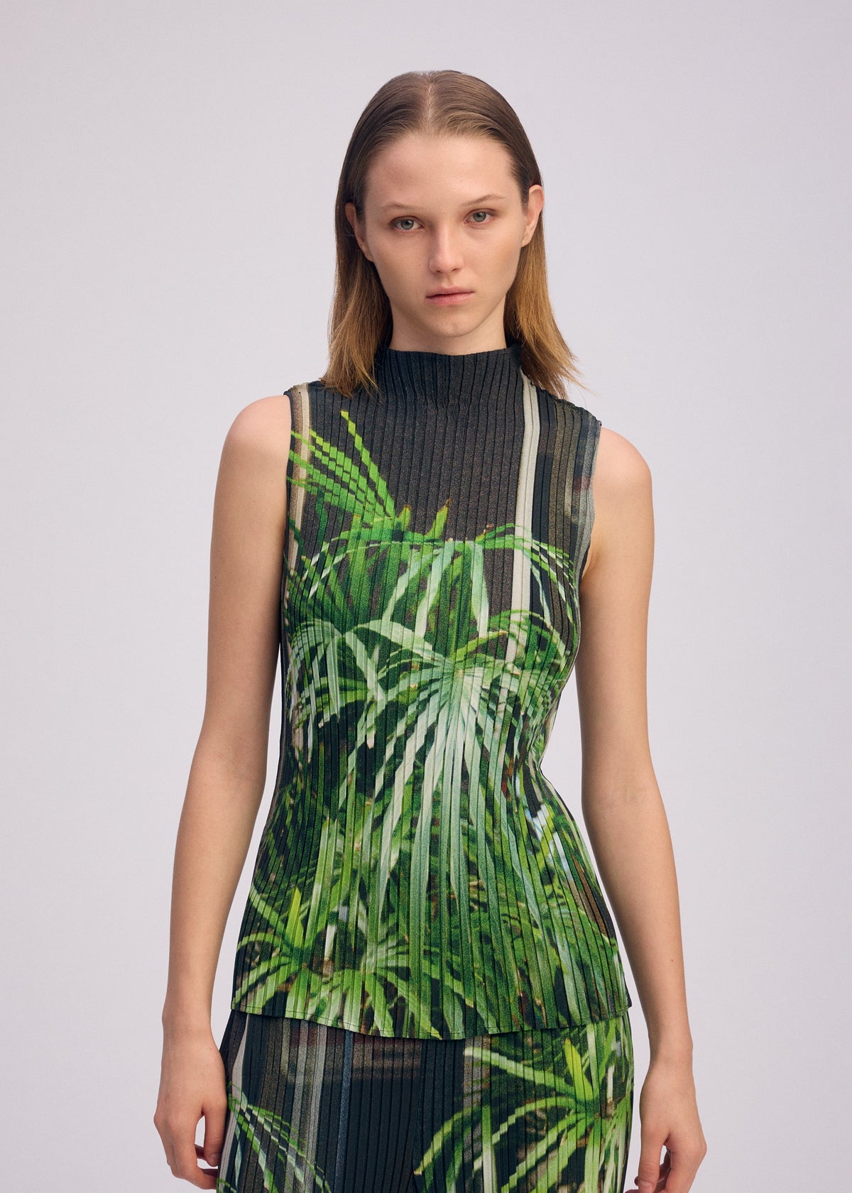 A model wears the ISSEY MIYAKE URBAN JUNGLE PLEATS shirt.