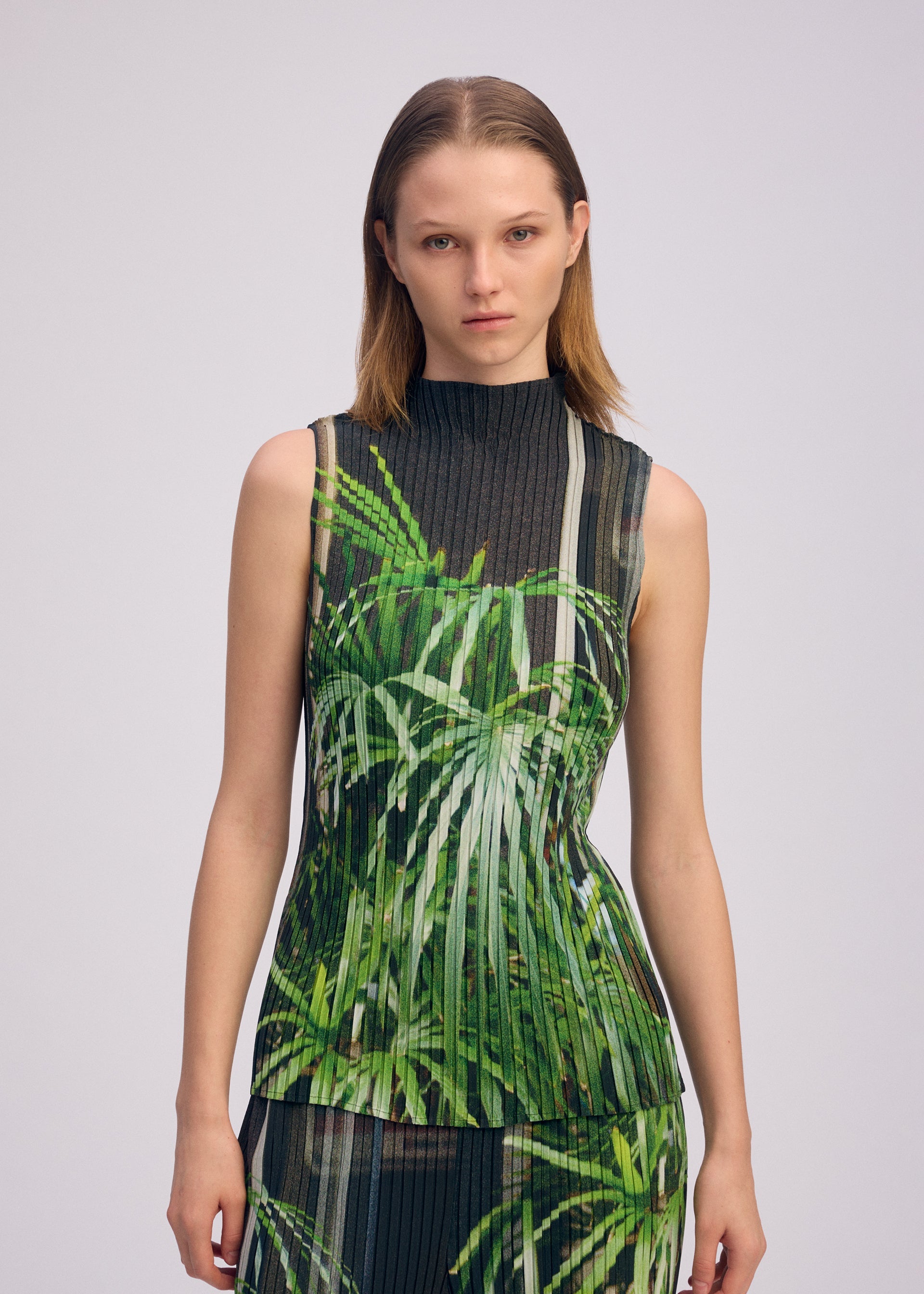 A model wears the ISSEY MIYAKE URBAN JUNGLE PLEATS shirt.