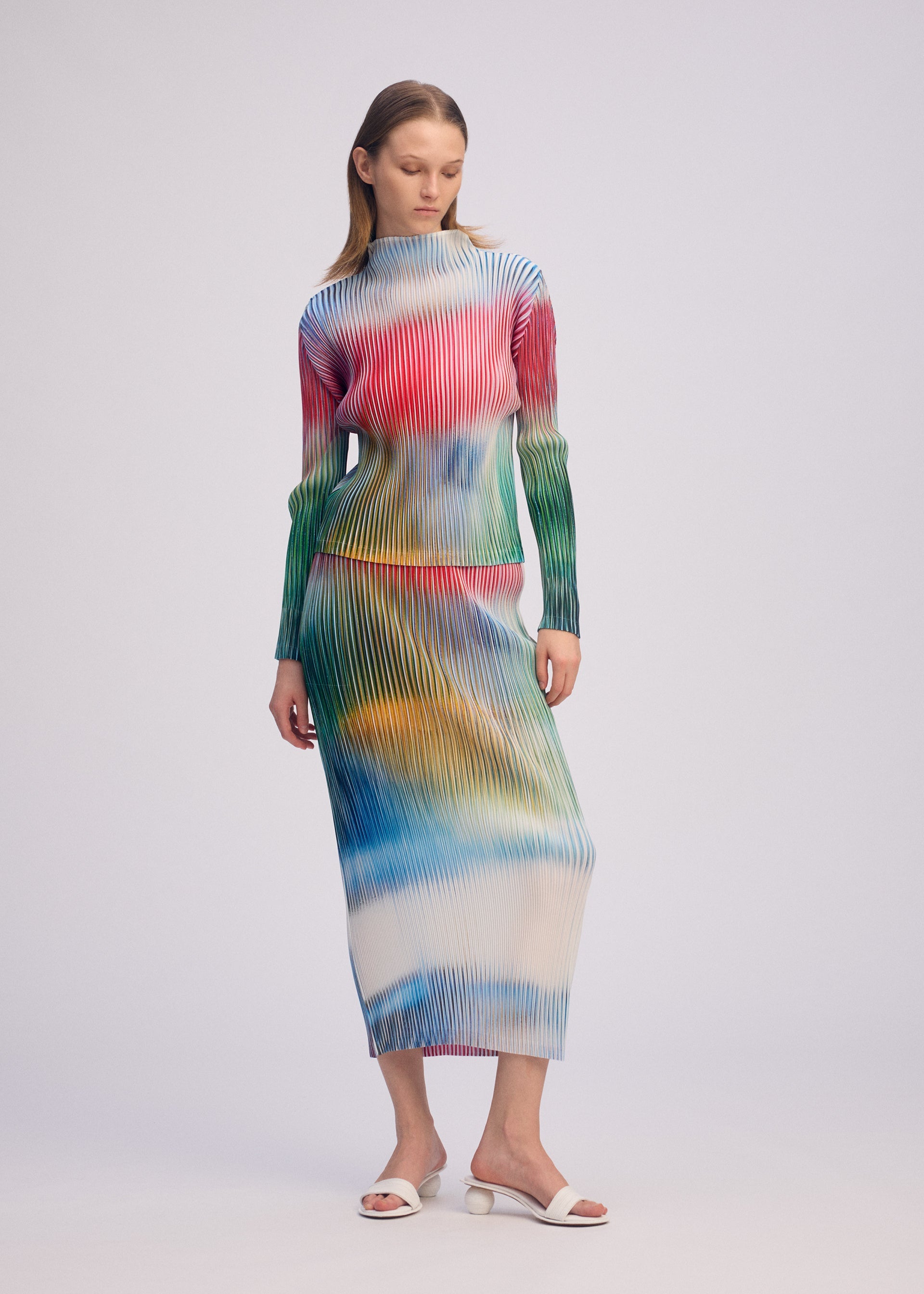 A model wears the ISSEY MIYAKE OBSCURE PLEATS clothing.