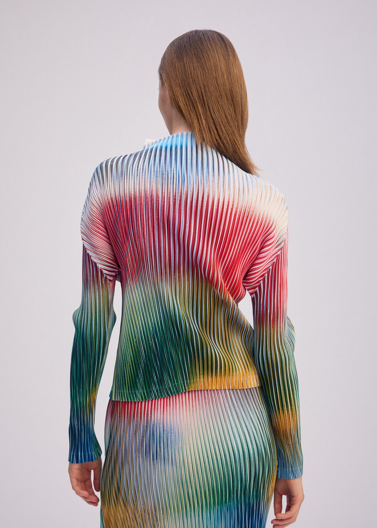 A model wears the ISSEY MIYAKE OBSCURE PLEATS clothing.