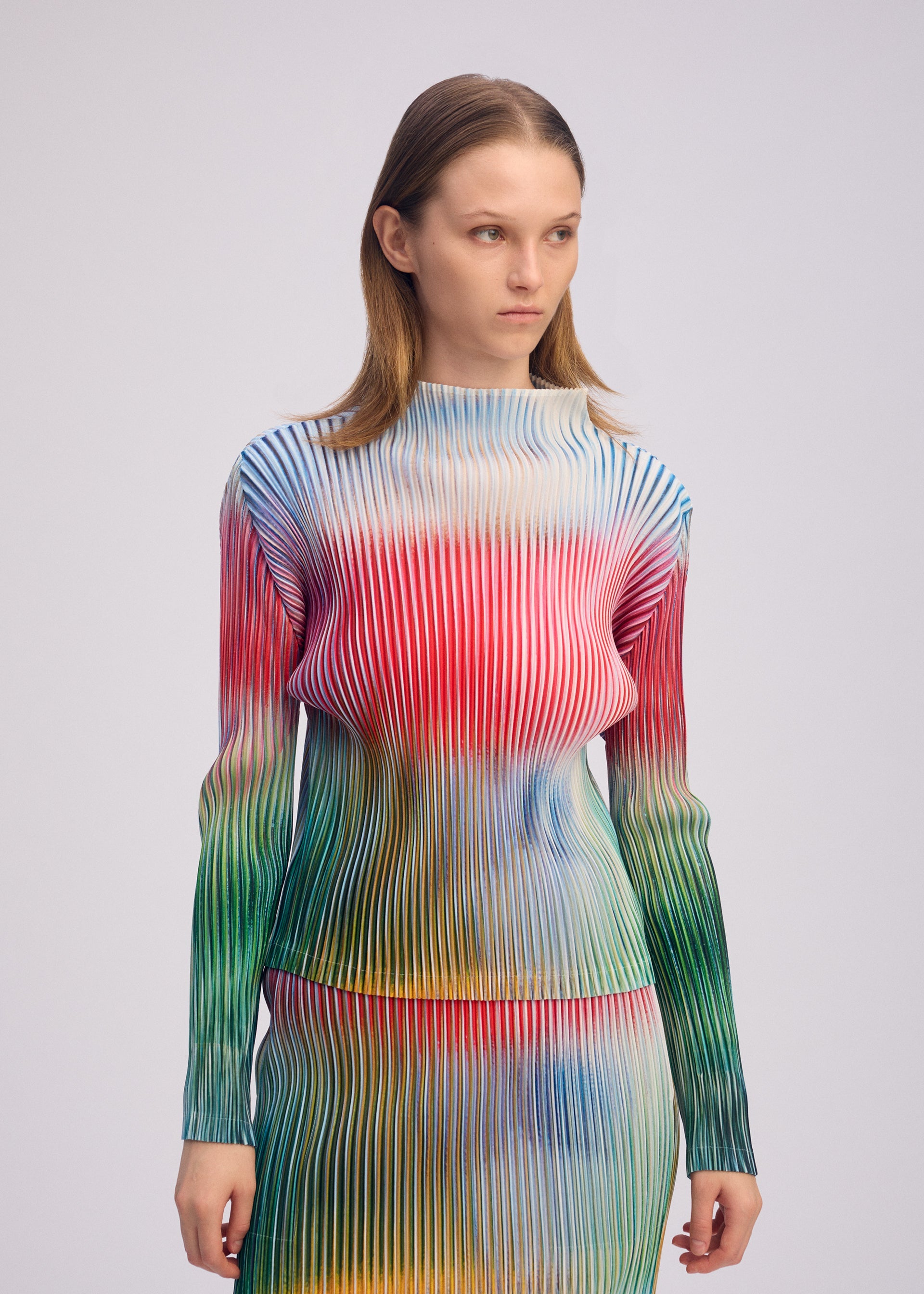 A model wears the ISSEY MIYAKE OBSCURE PLEATS clothing.