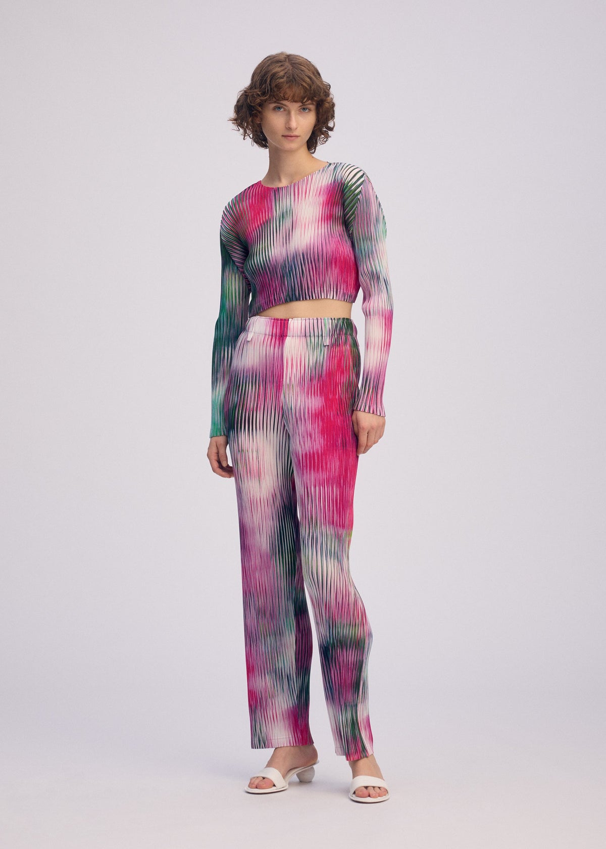 A model wears the ISSEY MIYAKE OBSCURE PLEATS clothing.