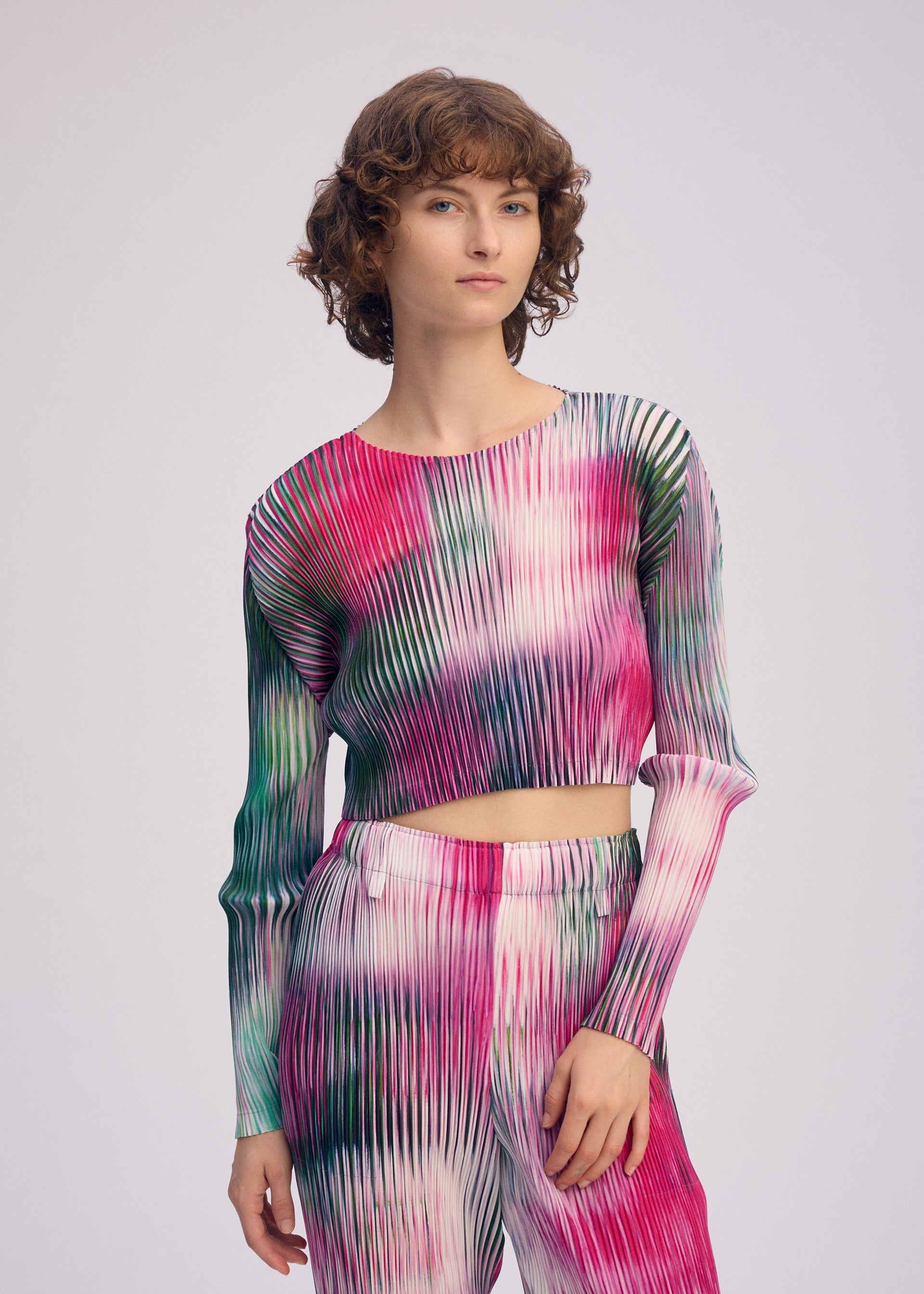 A model wears the ISSEY MIYAKE OBSCURE PLEATS clothing.