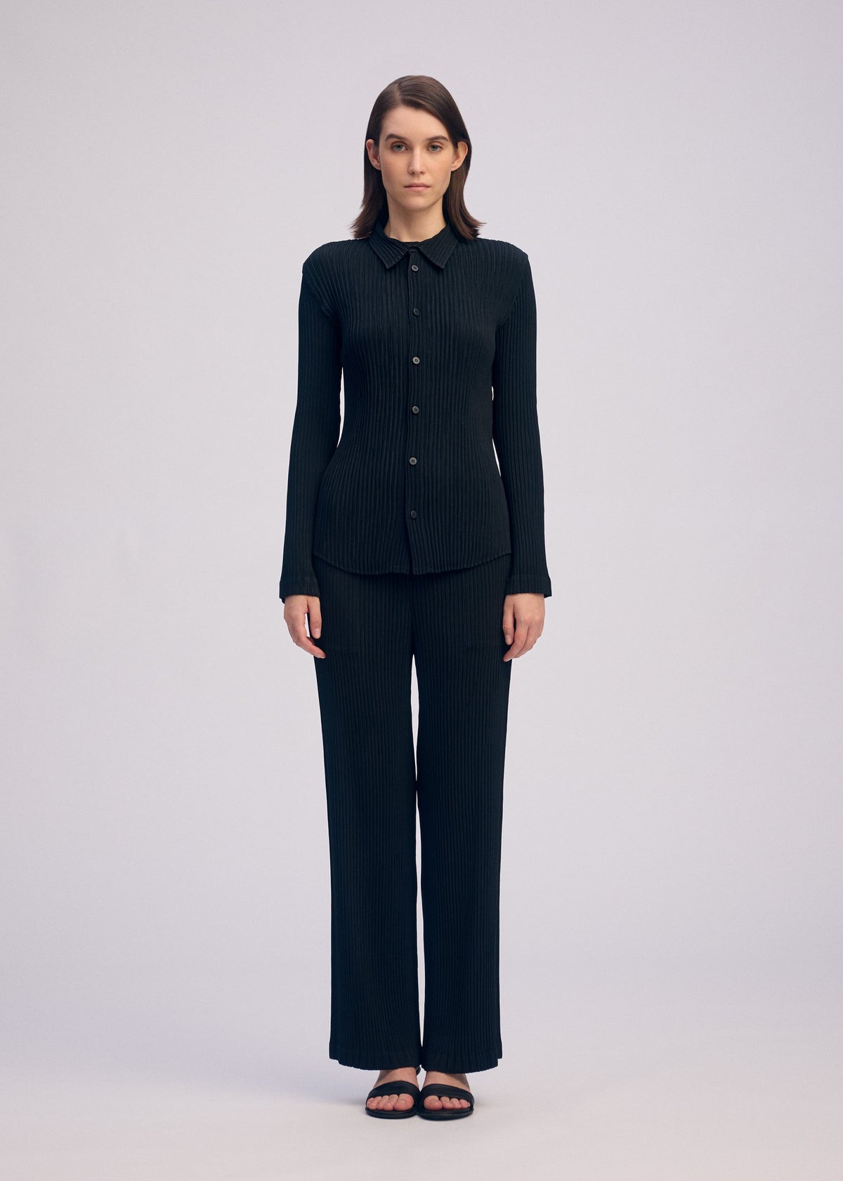 A model wears the ISSEY MIYAKE HATCHING PLEATS shirt.
