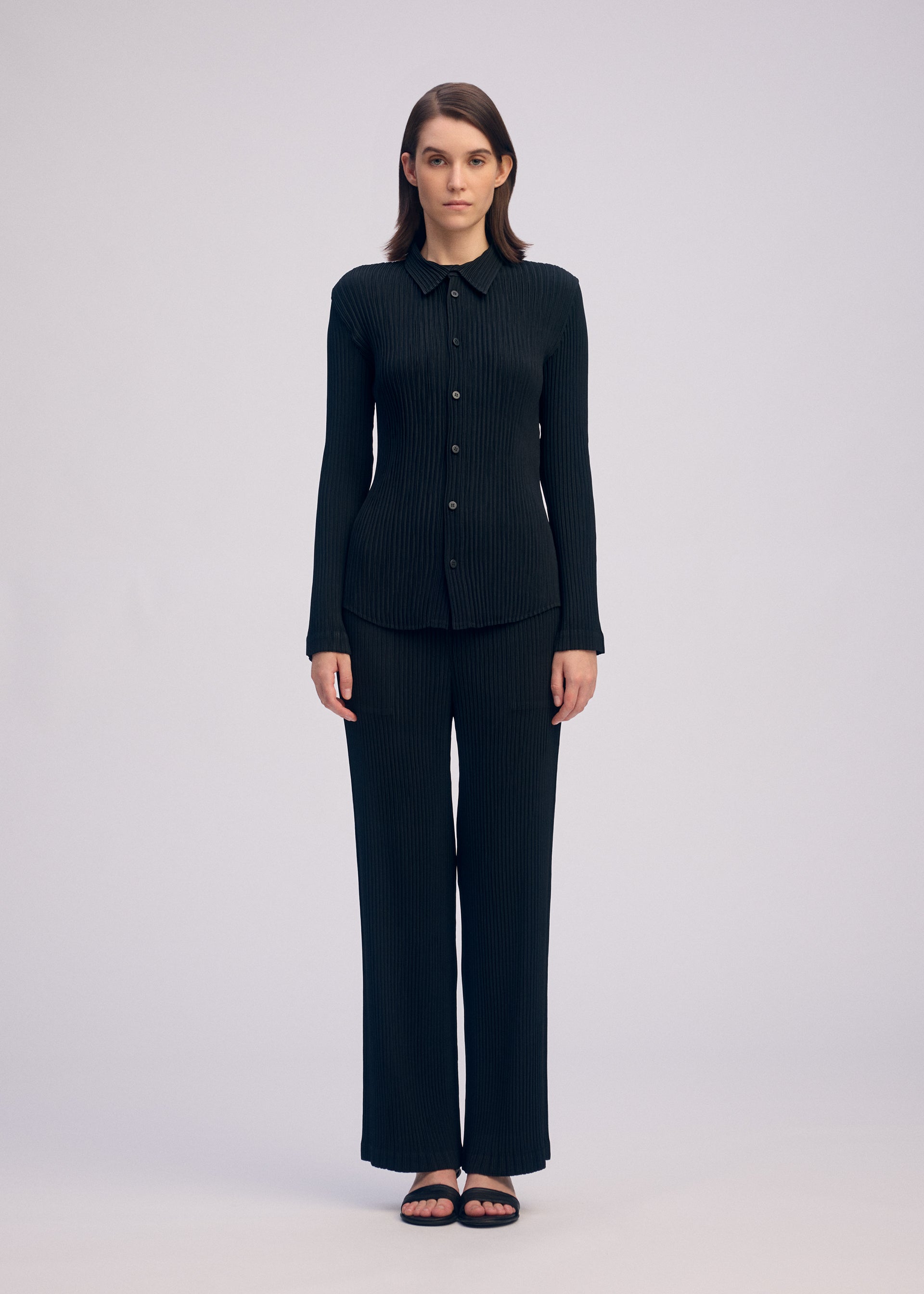 A model wears the ISSEY MIYAKE HATCHING PLEATS shirt.