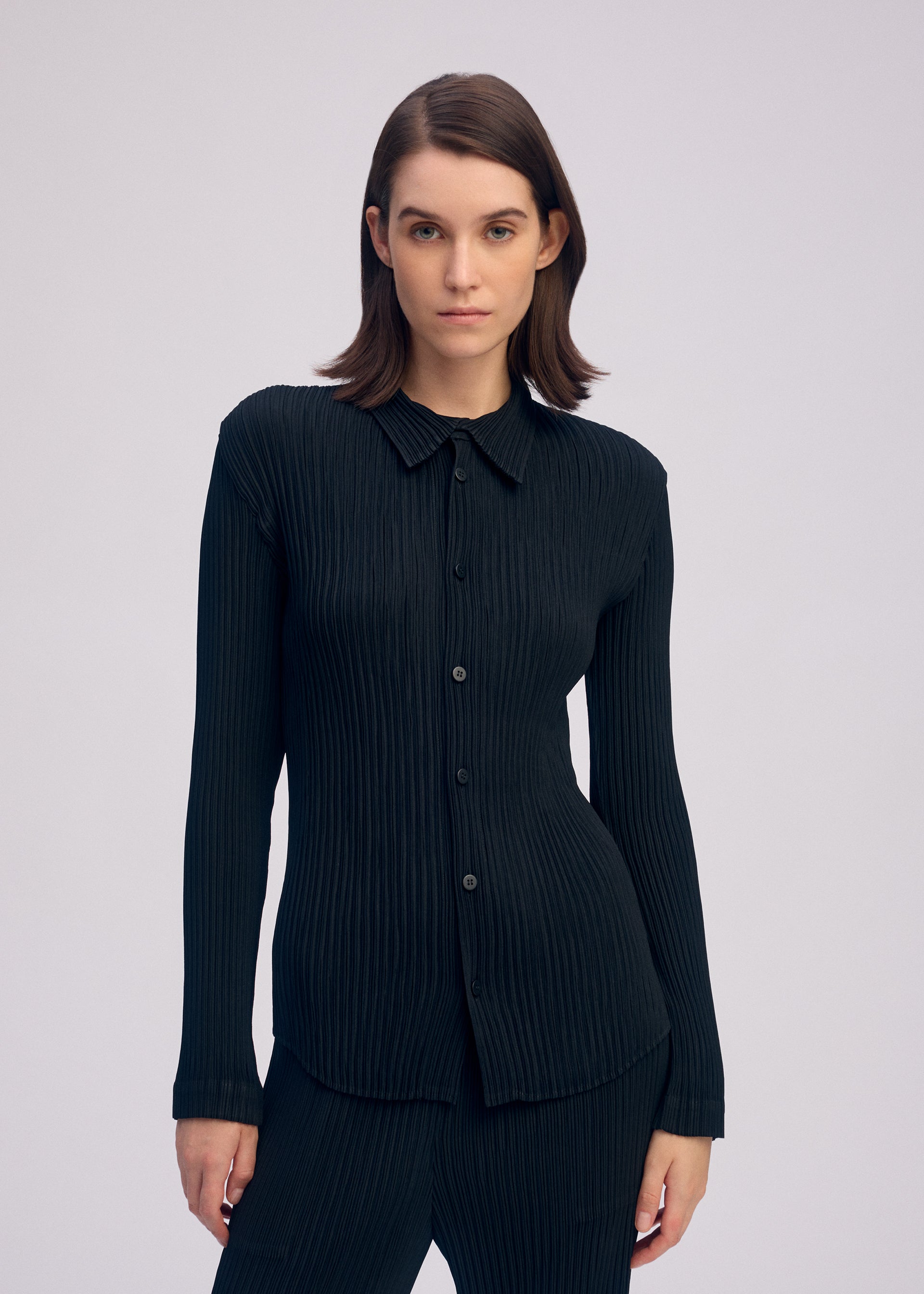 A model wears the ISSEY MIYAKE HATCHING PLEATS shirt.