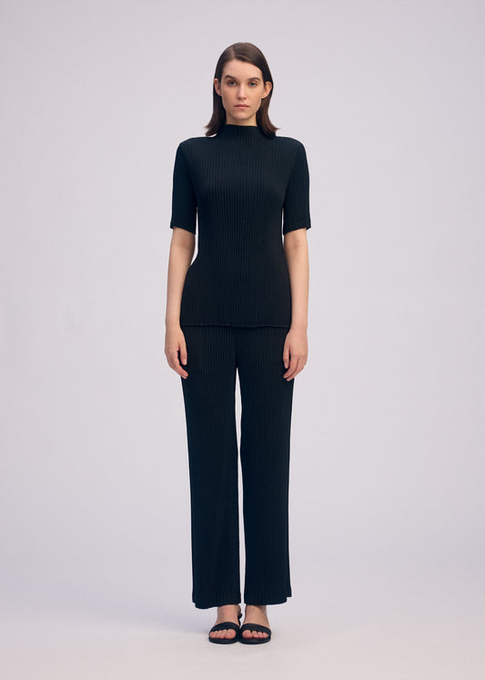 A model wears the ISSEY MIYAKE HATCHING PLEATS shirt.